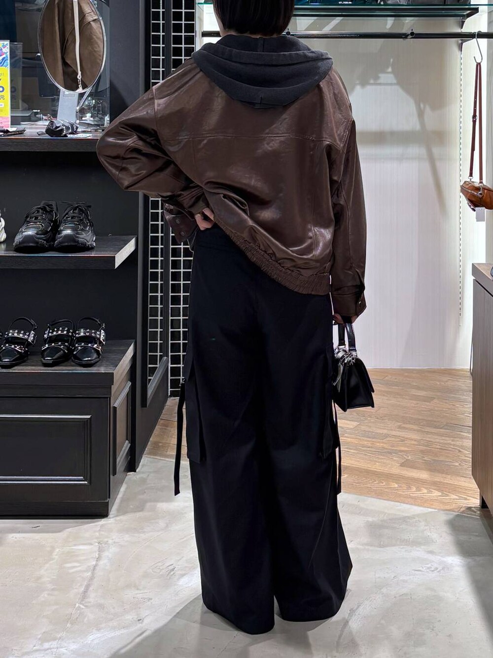 ブラウン系のブルゾン、その他のハンドバッグ、ブラック系のパーカーを着用したレディースの秋コーディネートの3枚目の写真