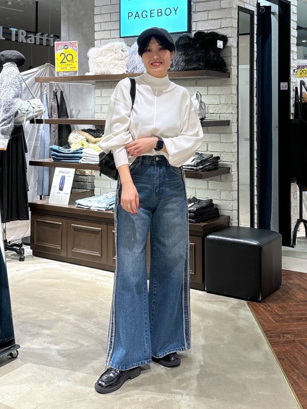 ホワイト系のニット/セーター、ブラック系のショルダーバッグ、ブルー系のデニムパンツを着用したレディースの冬コーディネートの6枚目の写真