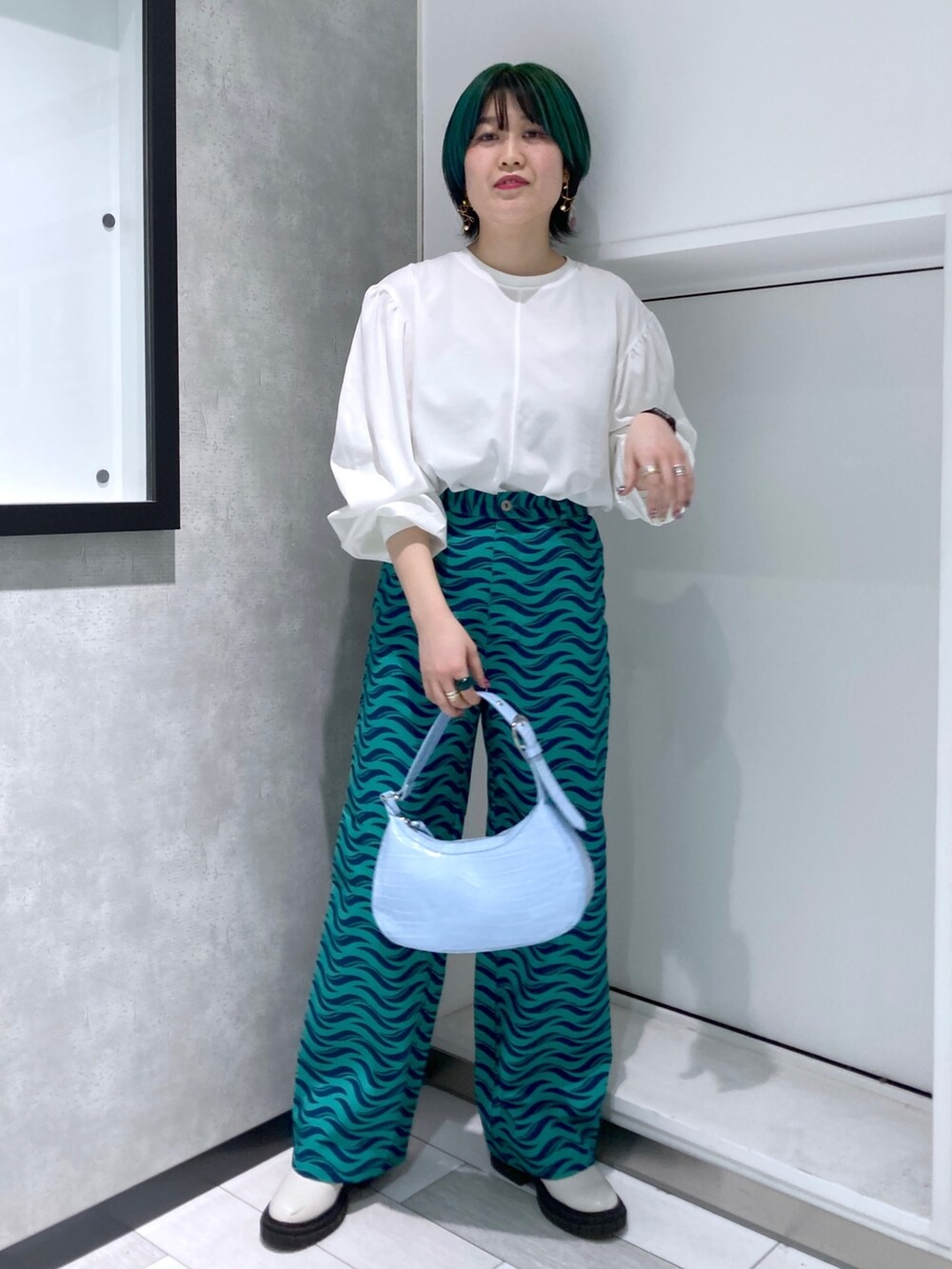 ホワイト系のTシャツ/カットソー、ブラック系のミリタリージャケット、グリーン系のパンツを着用したレディースの春コーディネートの4枚目の写真