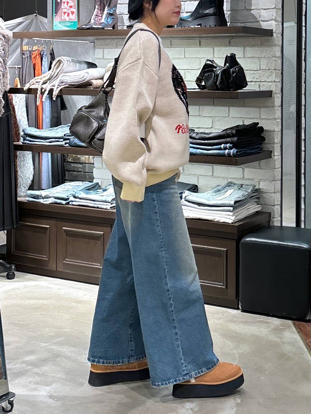 その他のショルダーバッグ、ベージュ系のブーツ、ブルー系のデニムパンツを着用したレディースの冬コーディネートの3枚目の写真