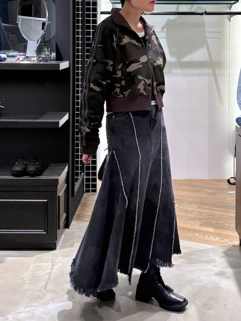 ブラック系のブーツ、ブラック系のショルダーバッグ、ブラック系のデニムスカートを着用したレディースの春コーディネートの3枚目の写真