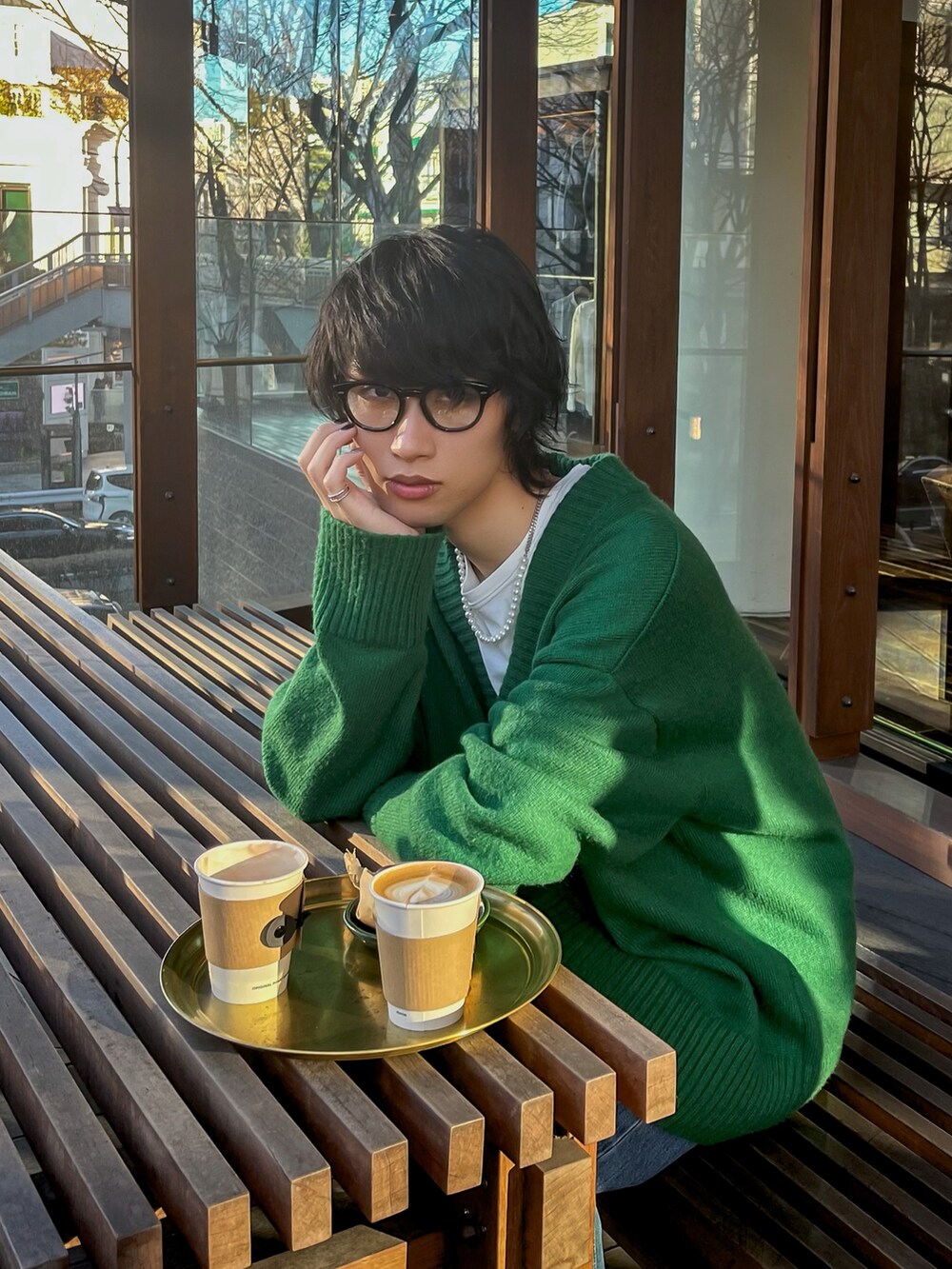 グリーン系のニット/セーター、ホワイト系のTシャツ/カットソー、ブルー系のデニムパンツを着用したメンズの春コーディネートの2枚目の写真