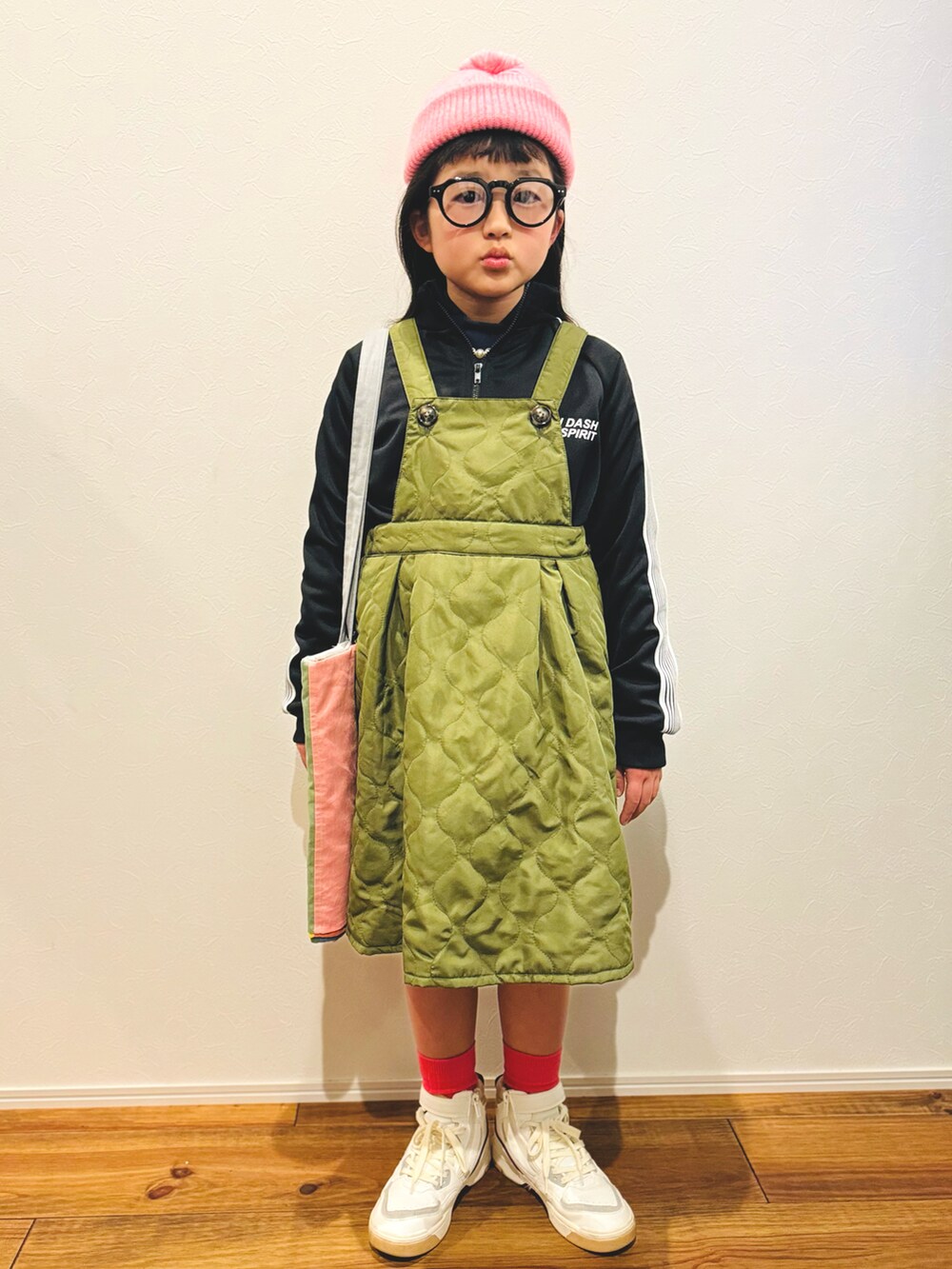 ブラック系のジャージ、グリーン系のサロペット/オーバーオール、ホワイト系のスニーカーを着用したキッズの冬コーディネートの3枚目の写真