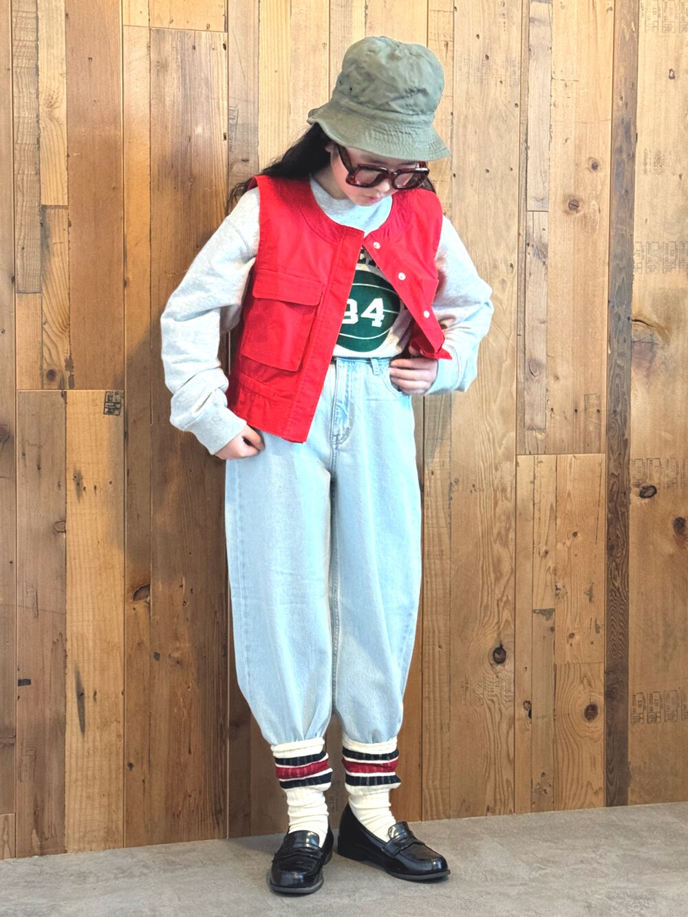 レッド系のベスト、グレー系のスウェット、ブルー系のデニムパンツを着用したキッズの冬コーディネートの5枚目の写真