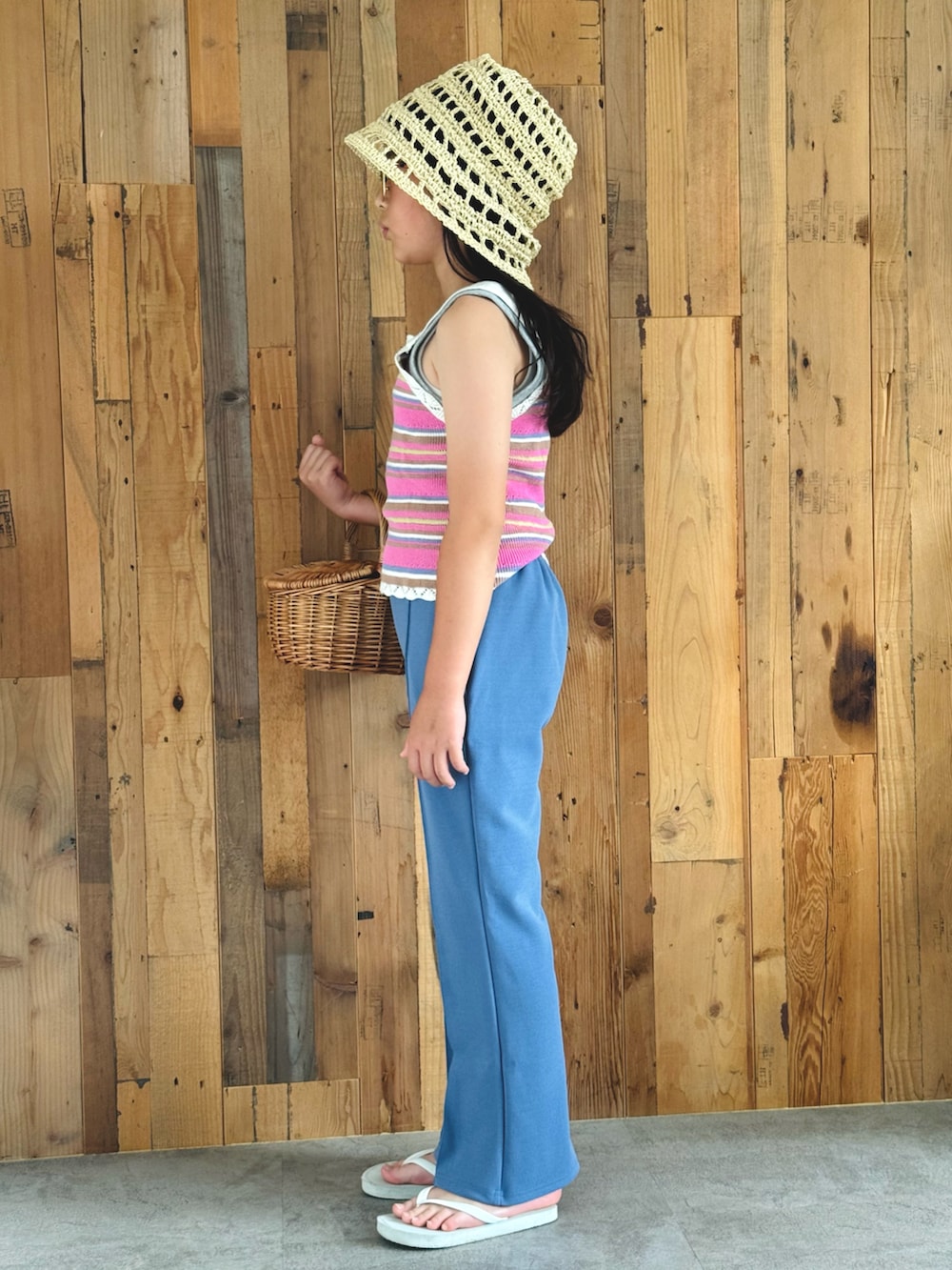 ピンク系のベスト、ブルー系のスラックス、ホワイト系のサンダルを着用したキッズの夏コーディネートの2枚目の写真