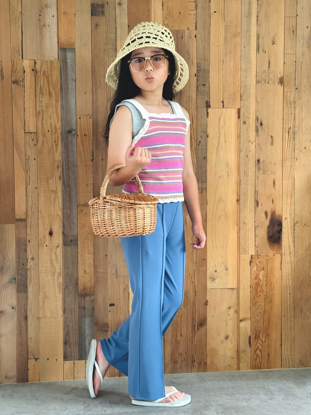 ピンク系のベスト、ブルー系のスラックス、ホワイト系のサンダルを着用したキッズの夏コーディネートの5枚目の写真