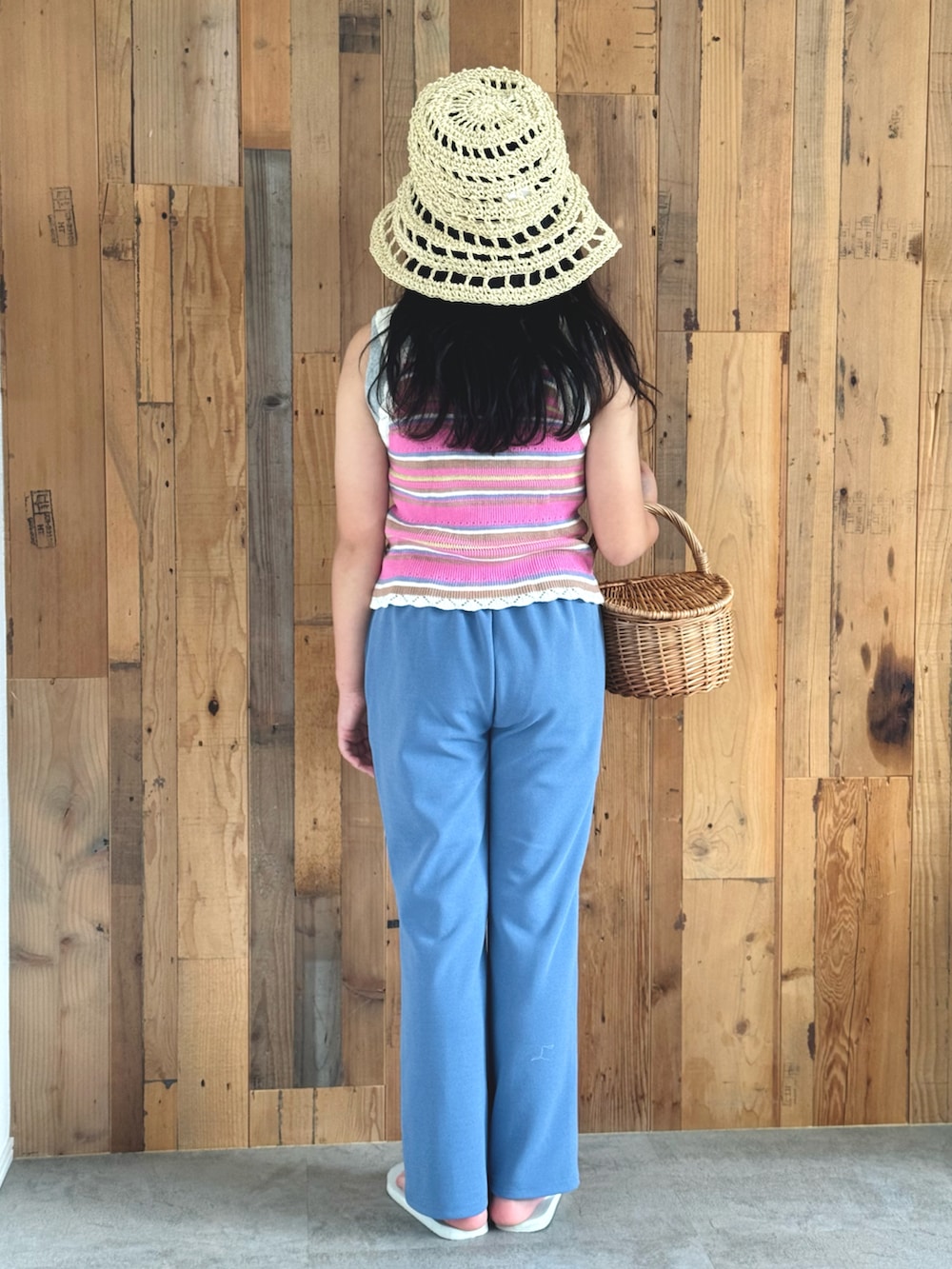 ピンク系のベスト、ブルー系のスラックス、ホワイト系のサンダルを着用したキッズの夏コーディネートの3枚目の写真