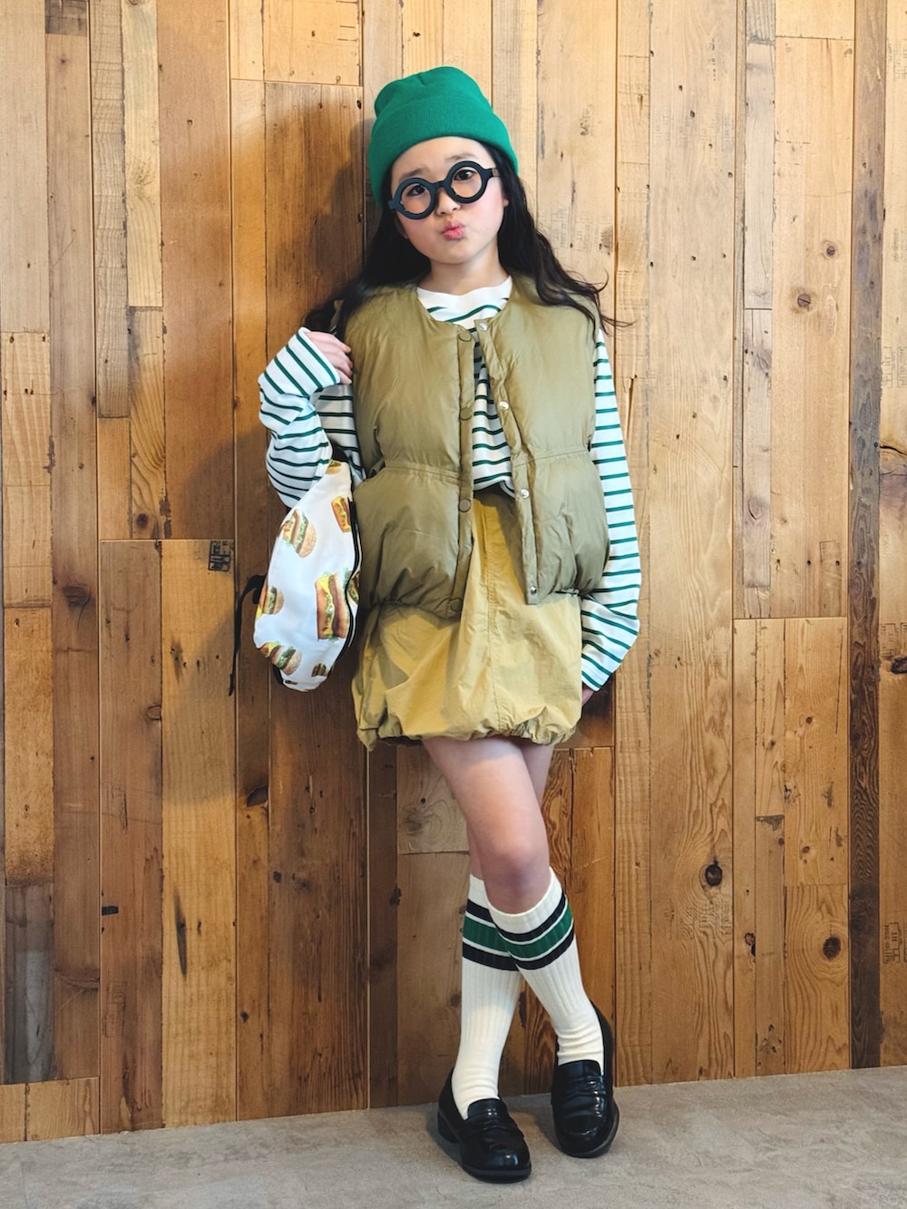 グリーン系のTシャツ/カットソー、ベージュ系のベスト、ベージュ系のスカートを着用したキッズの冬コーディネートの5枚目の写真