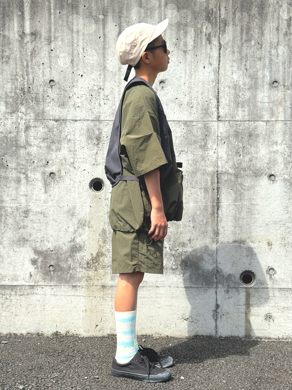 グリーン系のTシャツ/カットソー、グリーン系のその他パンツ、ブラック系のベストを着用したキッズの春コーディネートの2枚目の写真