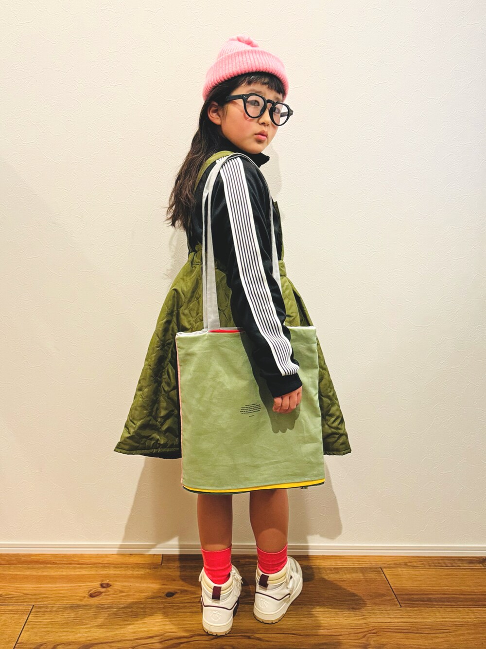 ブラック系のジャージ、グリーン系のサロペット/オーバーオール、ホワイト系のスニーカーを着用したキッズの冬コーディネートの4枚目の写真