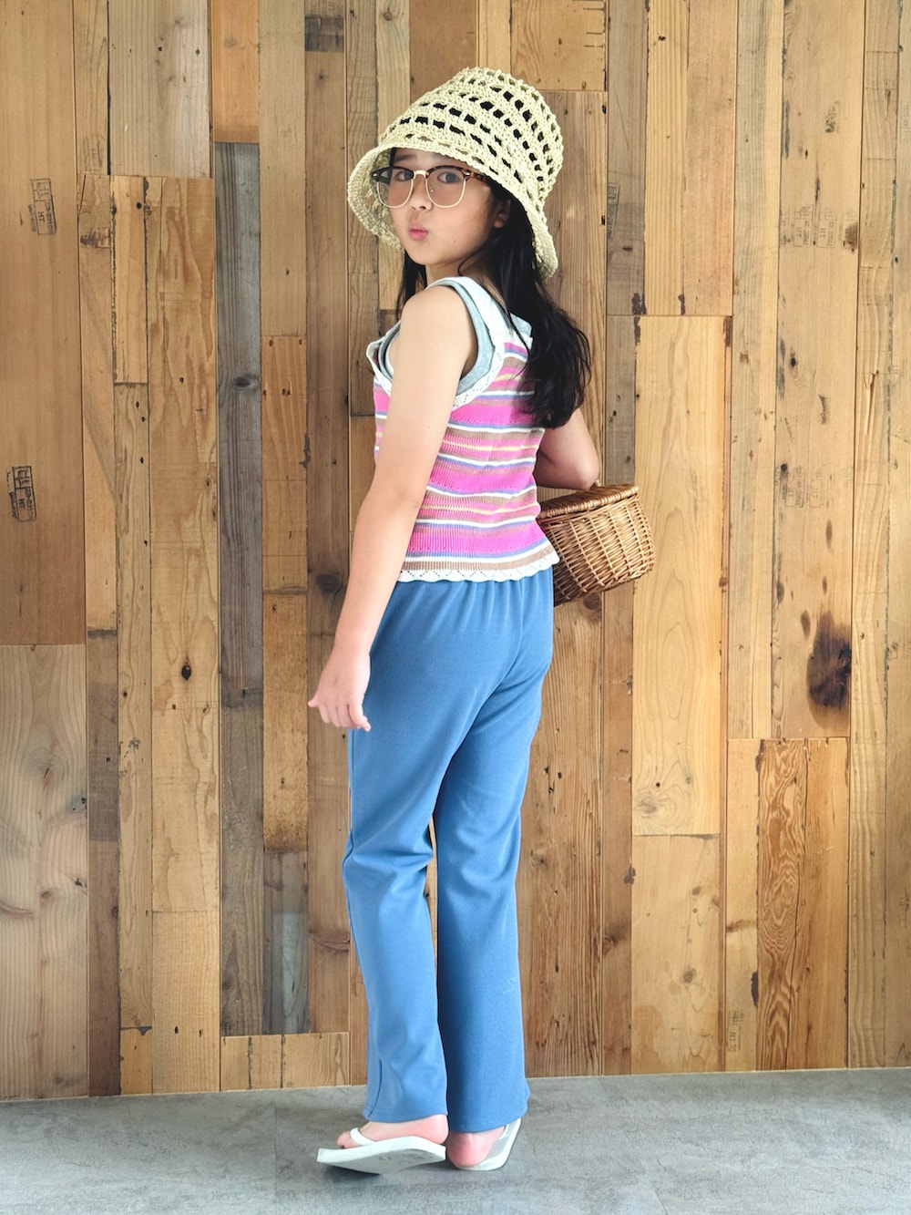 ピンク系のベスト、ブルー系のスラックス、ホワイト系のサンダルを着用したキッズの夏コーディネートの4枚目の写真