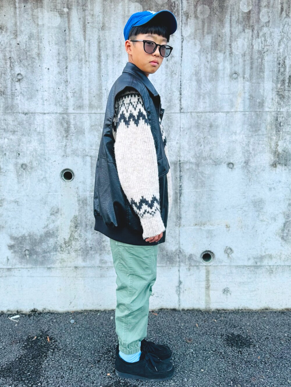 ブラック系のベスト、グリーン系のカーゴパンツ、ブラック系のモカシン/デッキシューズを着用したキッズの冬コーディネートの4枚目の写真