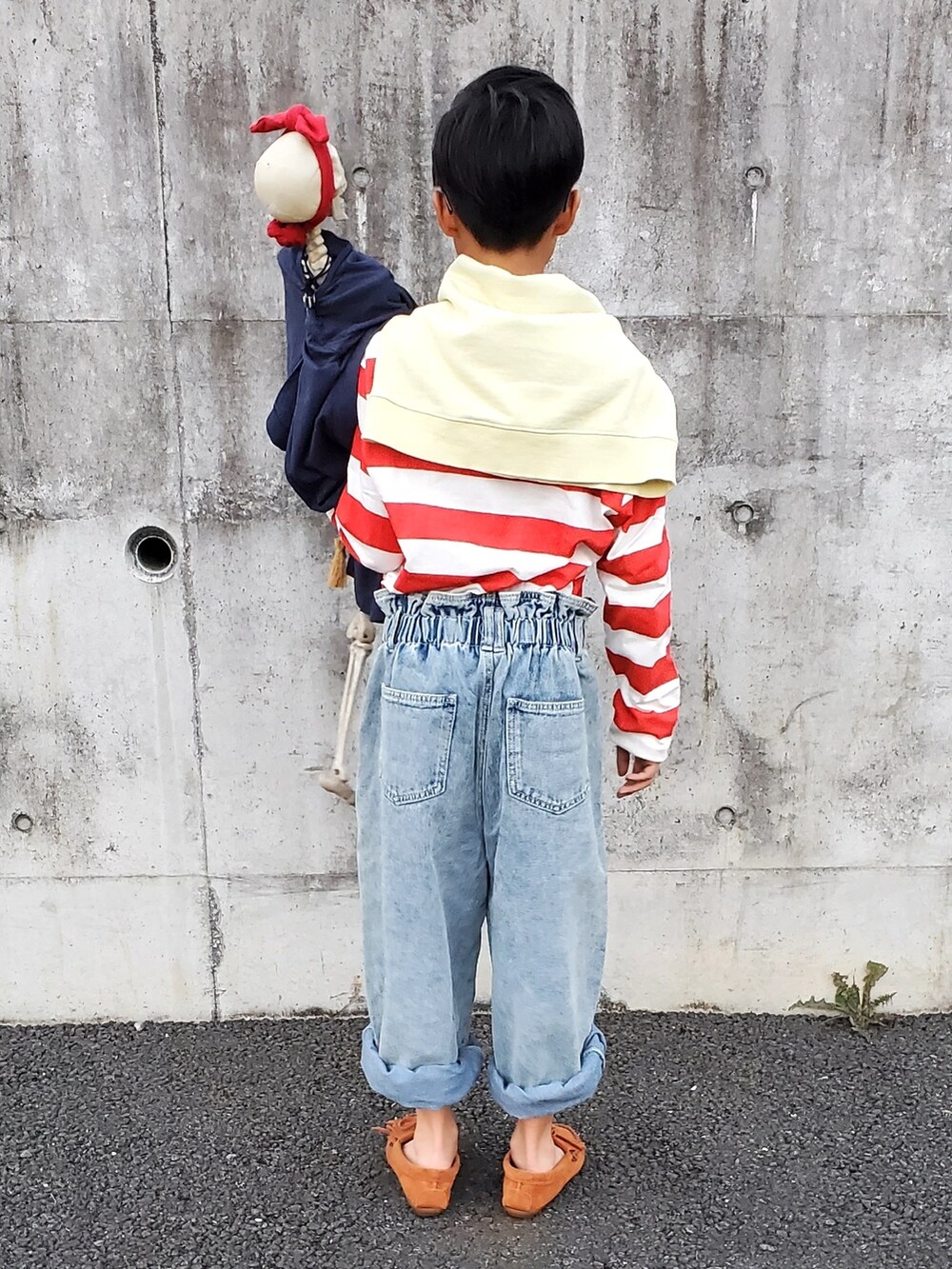 レッド系のTシャツ/カットソー、ブルー系のデニムパンツ、ブラウン系のモカシン/デッキシューズを着用したキッズの秋コーディネートの4枚目の写真