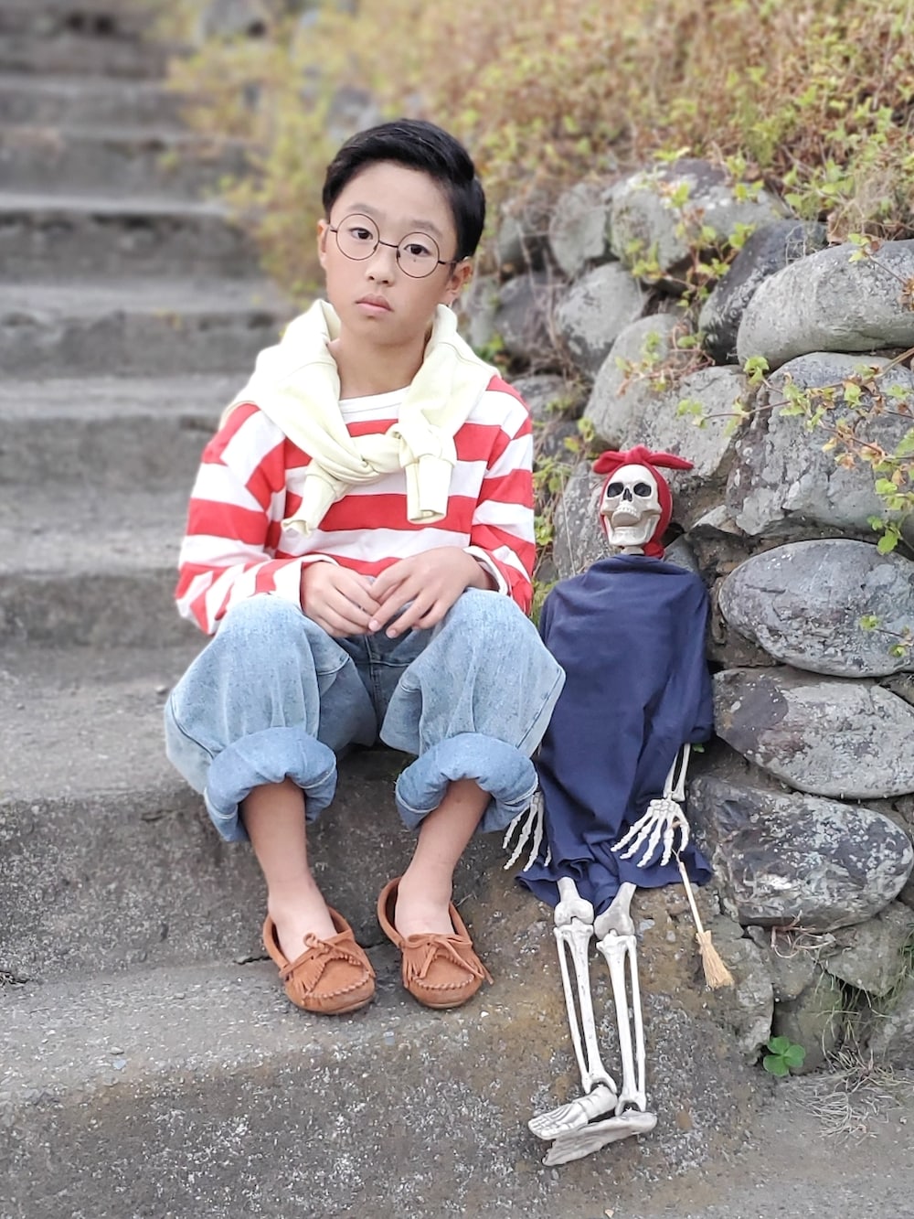 レッド系のTシャツ/カットソー、ブルー系のデニムパンツ、ブラウン系のモカシン/デッキシューズを着用したキッズの秋コーディネートの2枚目の写真