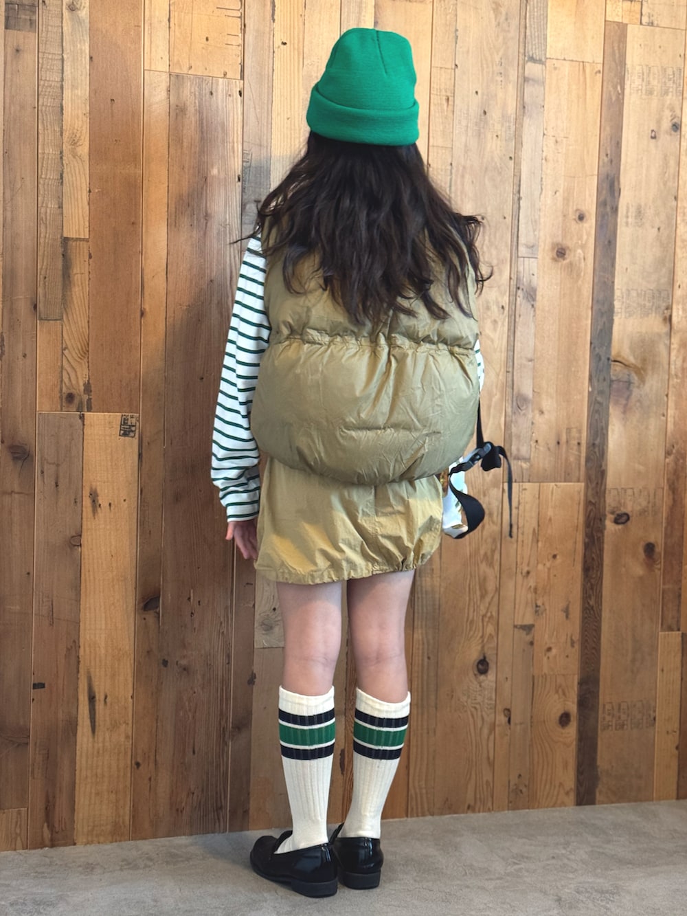 グリーン系のTシャツ/カットソー、ベージュ系のベスト、ベージュ系のスカートを着用したキッズの冬コーディネートの4枚目の写真