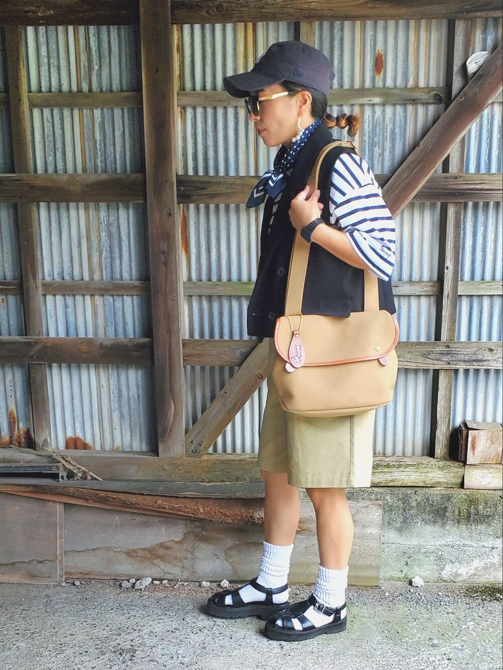ブラック系のサンダル、ベージュ系のチノパンツ、ブルー系のTシャツ/カットソーを着用したレディースの夏コーディネートの2枚目の写真
