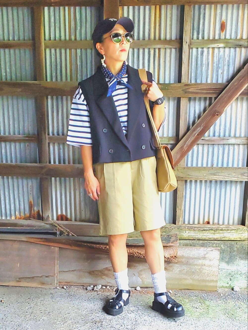 ブラック系のサンダル、ベージュ系のチノパンツ、ブルー系のTシャツ/カットソーを着用したレディースの夏コーディネートの5枚目の写真
