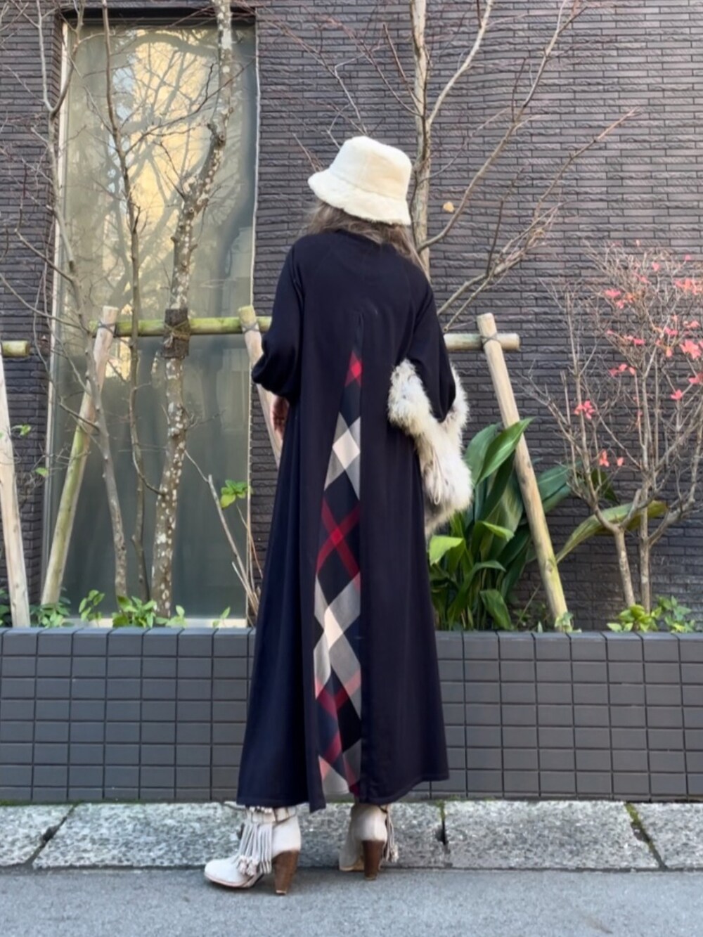 グレー系のベスト、ブルー系のワンピース、グレー系のブーツを着用したレディースの冬コーディネートの3枚目の写真