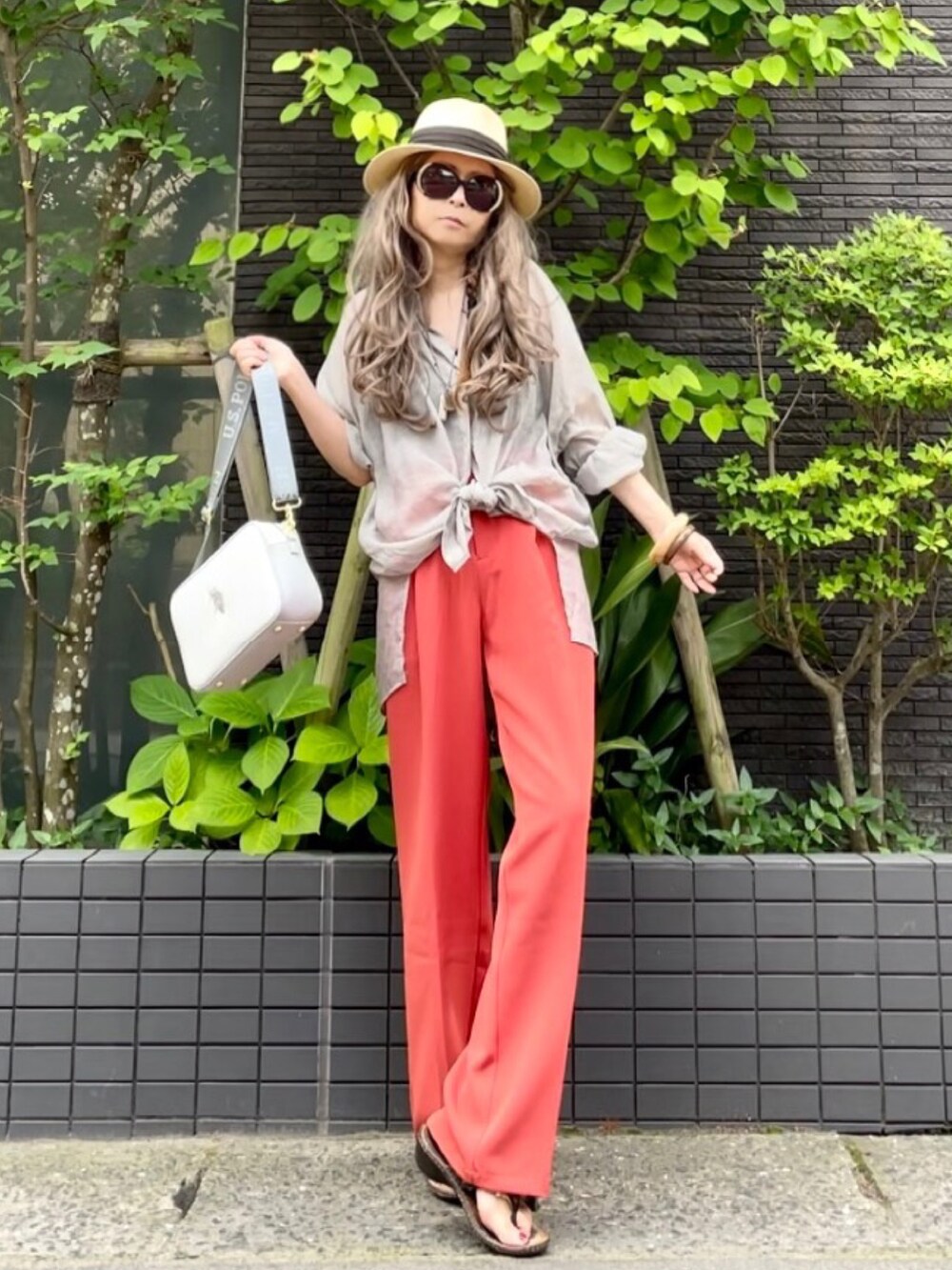 ブラウン系のタンクトップ、グレー系のシャツ/ブラウス、オレンジ系のスラックスを着用したレディースの夏コーディネートの2枚目の写真