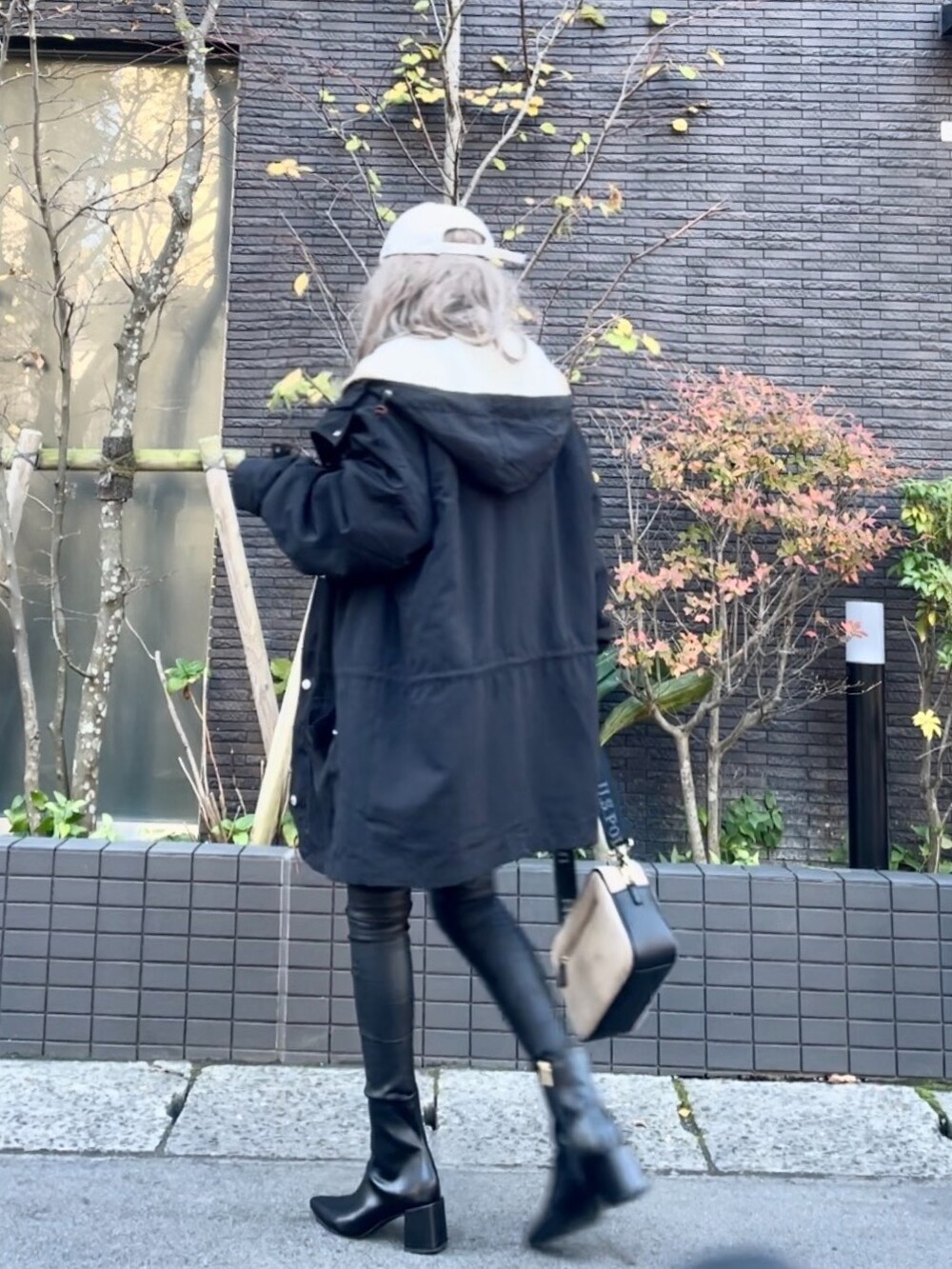 ブラック系のマウンテンパーカー、ホワイト系のニット/セーター、ブラック系のその他パンツを着用したレディースの秋コーディネートの5枚目の写真