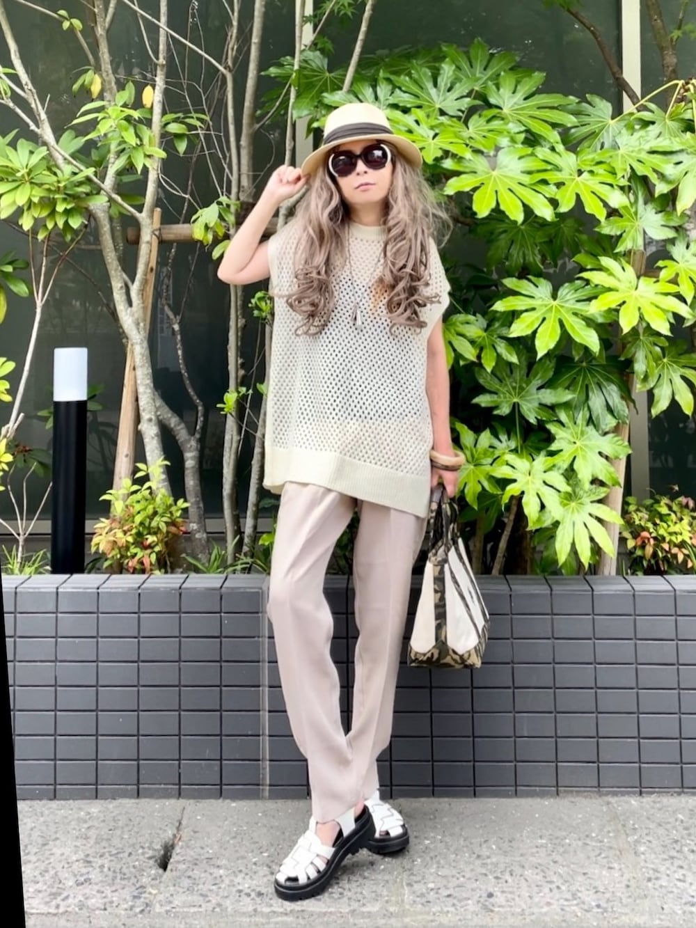 ホワイト系のベスト、ホワイト系のスラックス、ホワイト系のトートバッグを着用したレディースの夏コーディネートの2枚目の写真