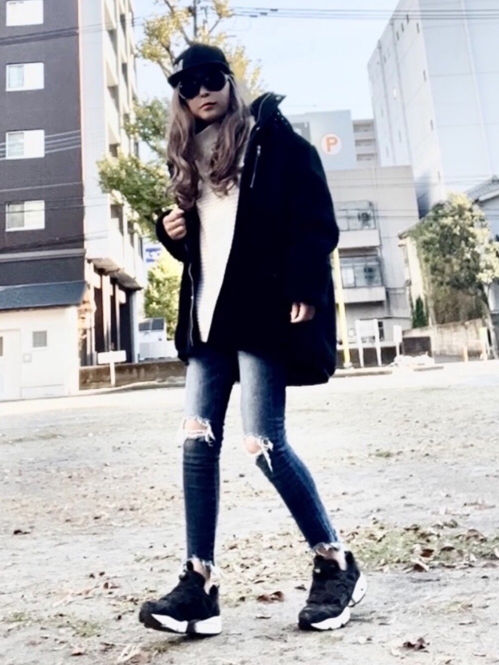 ホワイト系のニット/セーター、ブラック系のブルゾン、ブルー系のデニムパンツを着用したレディースの秋コーディネートの3枚目の写真