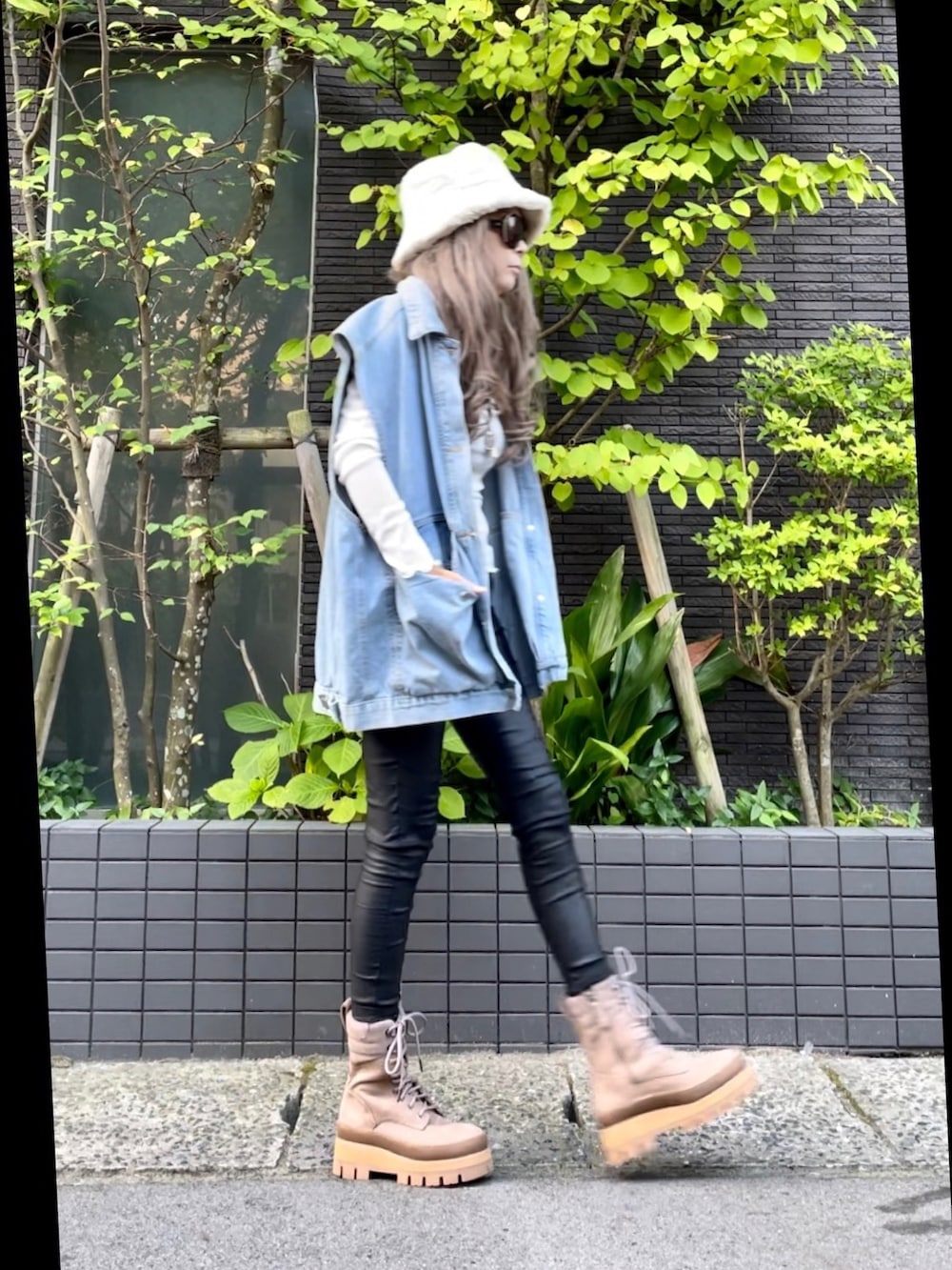 ブルー系のベスト、ブラック系のその他パンツ、ブラウン系のブーツを着用したレディースの秋コーディネートの4枚目の写真
