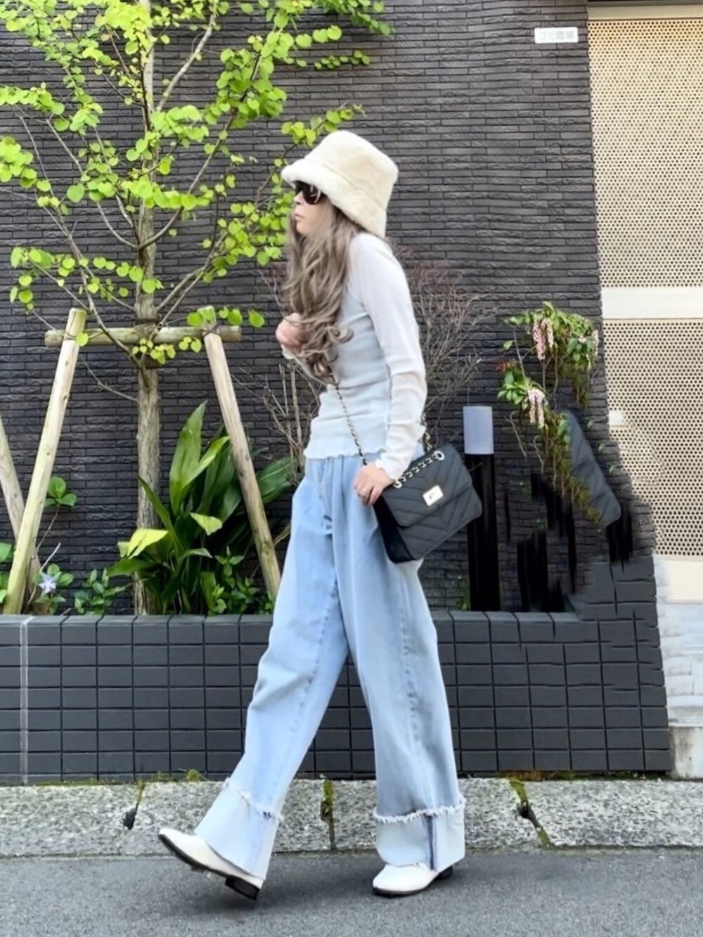 ホワイト系のTシャツ/カットソー、ブラック系のショルダーバッグ、ホワイト系のローファーを着用したレディースの春コーディネートの3枚目の写真