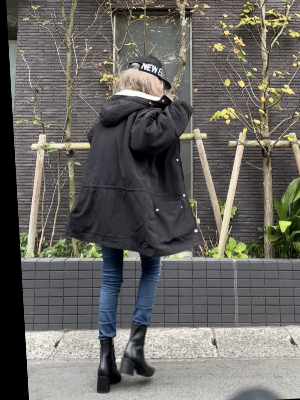 ブラック系のマウンテンパーカー、グレー系のニット/セーター、ブルー系のデニムパンツを着用したレディースの秋コーディネートの3枚目の写真