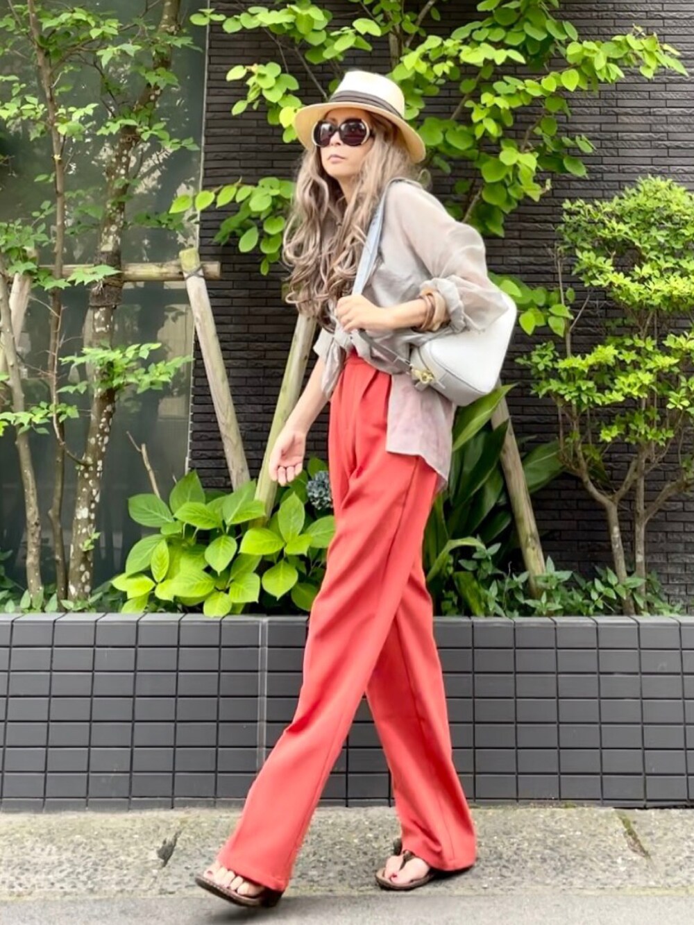 ブラウン系のタンクトップ、グレー系のシャツ/ブラウス、オレンジ系のスラックスを着用したレディースの夏コーディネートの4枚目の写真