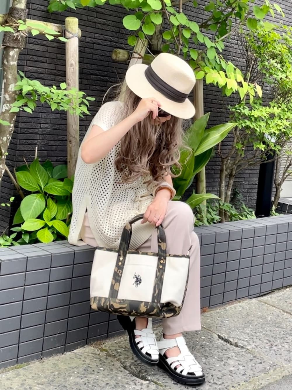 ホワイト系のベスト、ホワイト系のスラックス、ホワイト系のトートバッグを着用したレディースの夏コーディネートの3枚目の写真