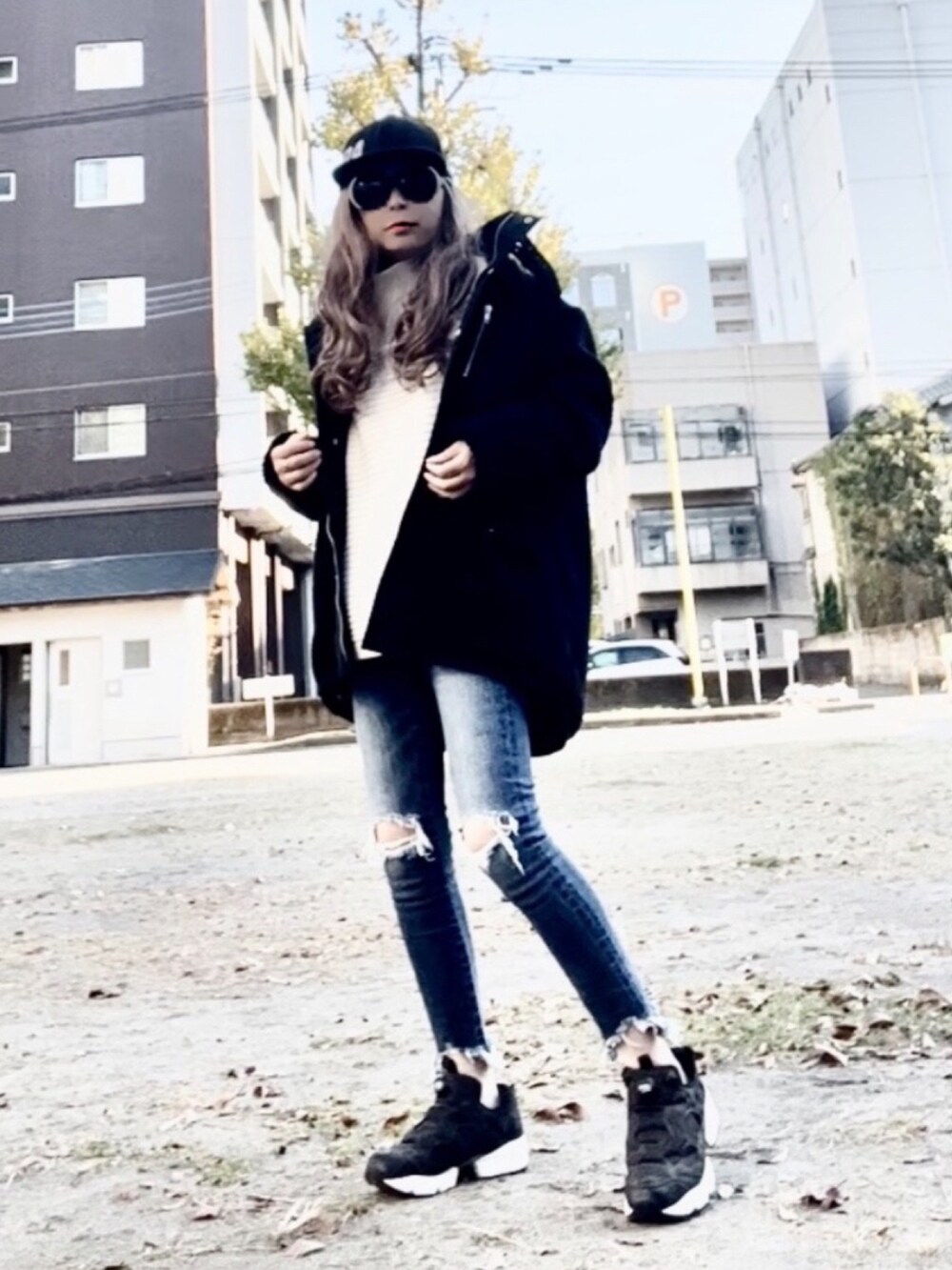 ホワイト系のニット/セーター、ブラック系のブルゾン、ブルー系のデニムパンツを着用したレディースの秋コーディネートの2枚目の写真