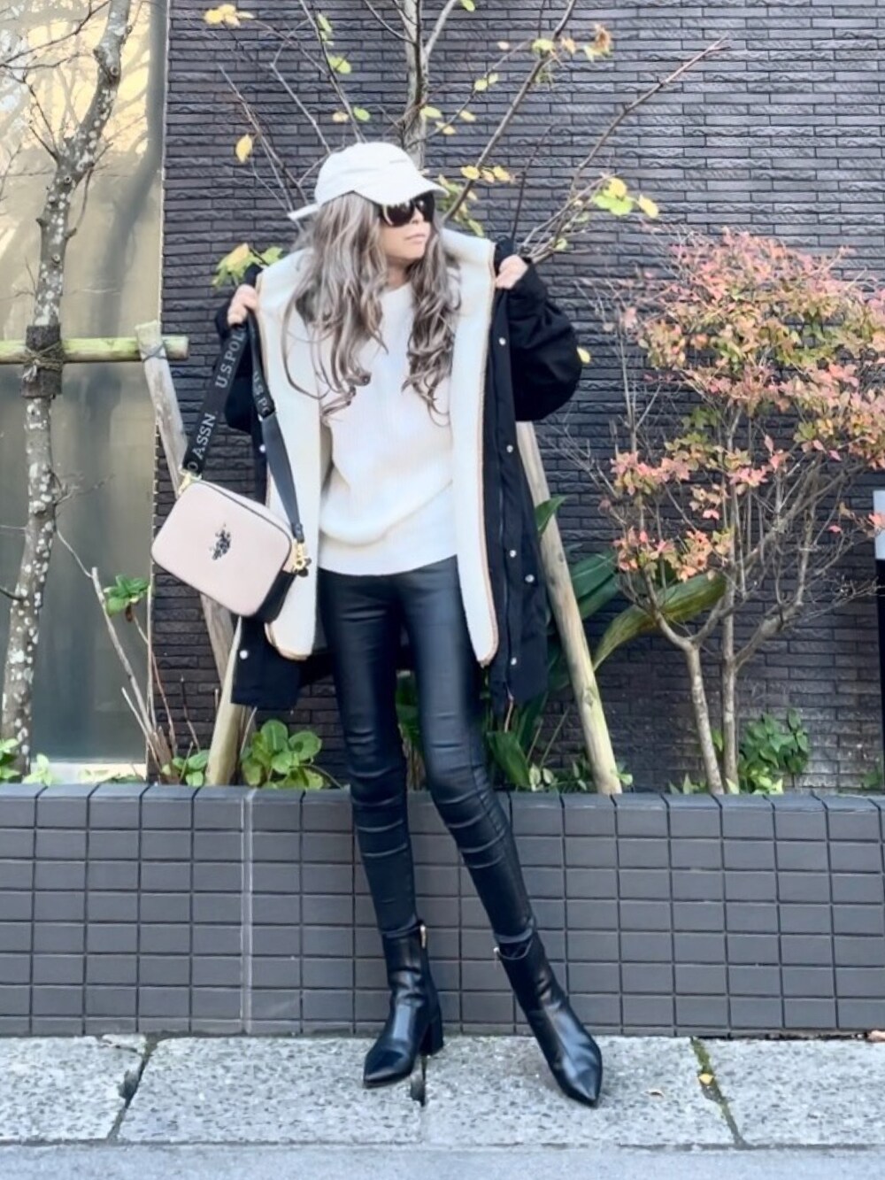 ブラック系のマウンテンパーカー、ホワイト系のニット/セーター、ブラック系のその他パンツを着用したレディースの秋コーディネートの4枚目の写真