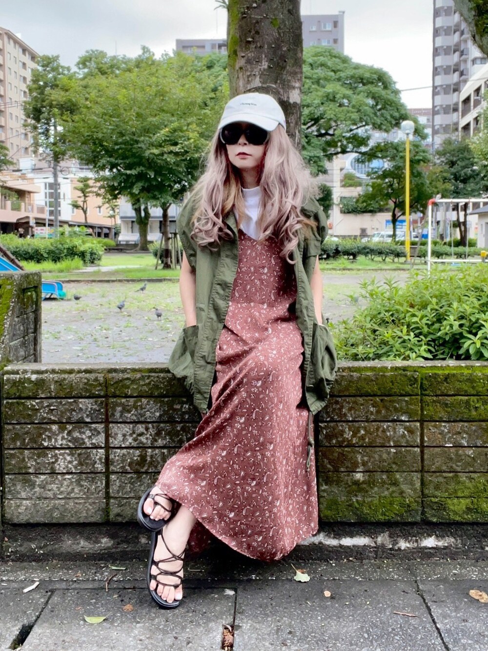 グリーン系のベスト、ブラウン系のワンピース、ブラック系のサンダルを着用したレディースの夏コーディネートの2枚目の写真