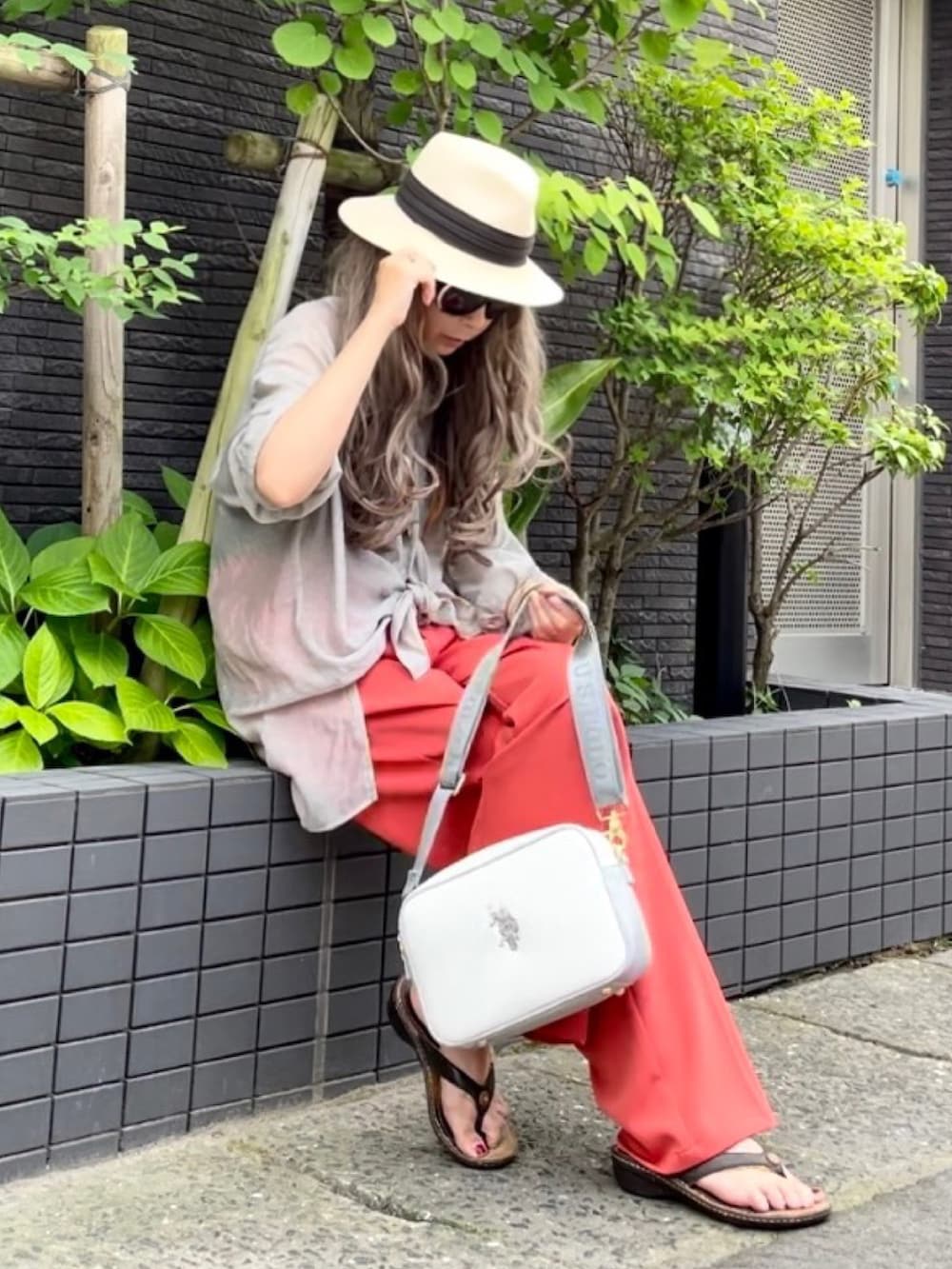 ブラウン系のタンクトップ、グレー系のシャツ/ブラウス、オレンジ系のスラックスを着用したレディースの夏コーディネートの5枚目の写真