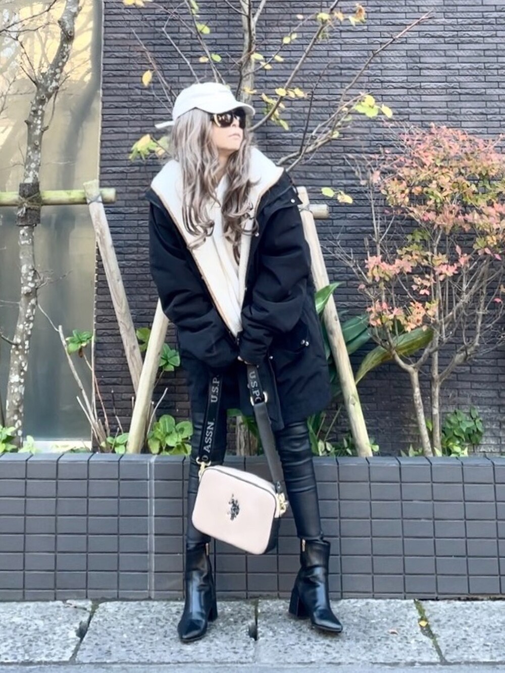 ブラック系のマウンテンパーカー、ホワイト系のニット/セーター、ブラック系のその他パンツを着用したレディースの秋コーディネートの3枚目の写真