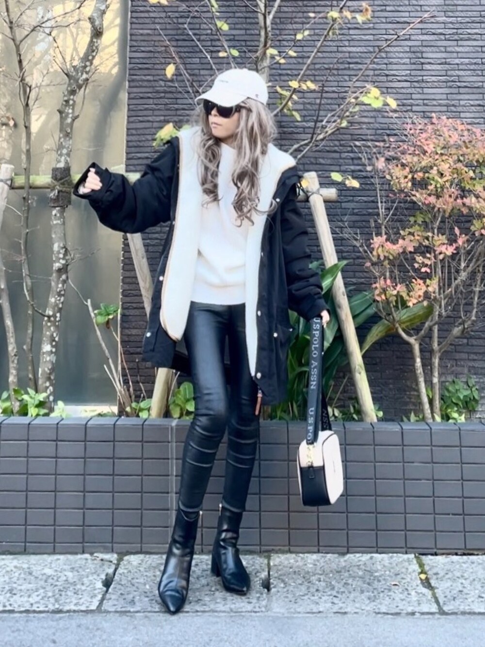 ブラック系のマウンテンパーカー、ホワイト系のニット/セーター、ブラック系のその他パンツを着用したレディースの秋コーディネートの2枚目の写真