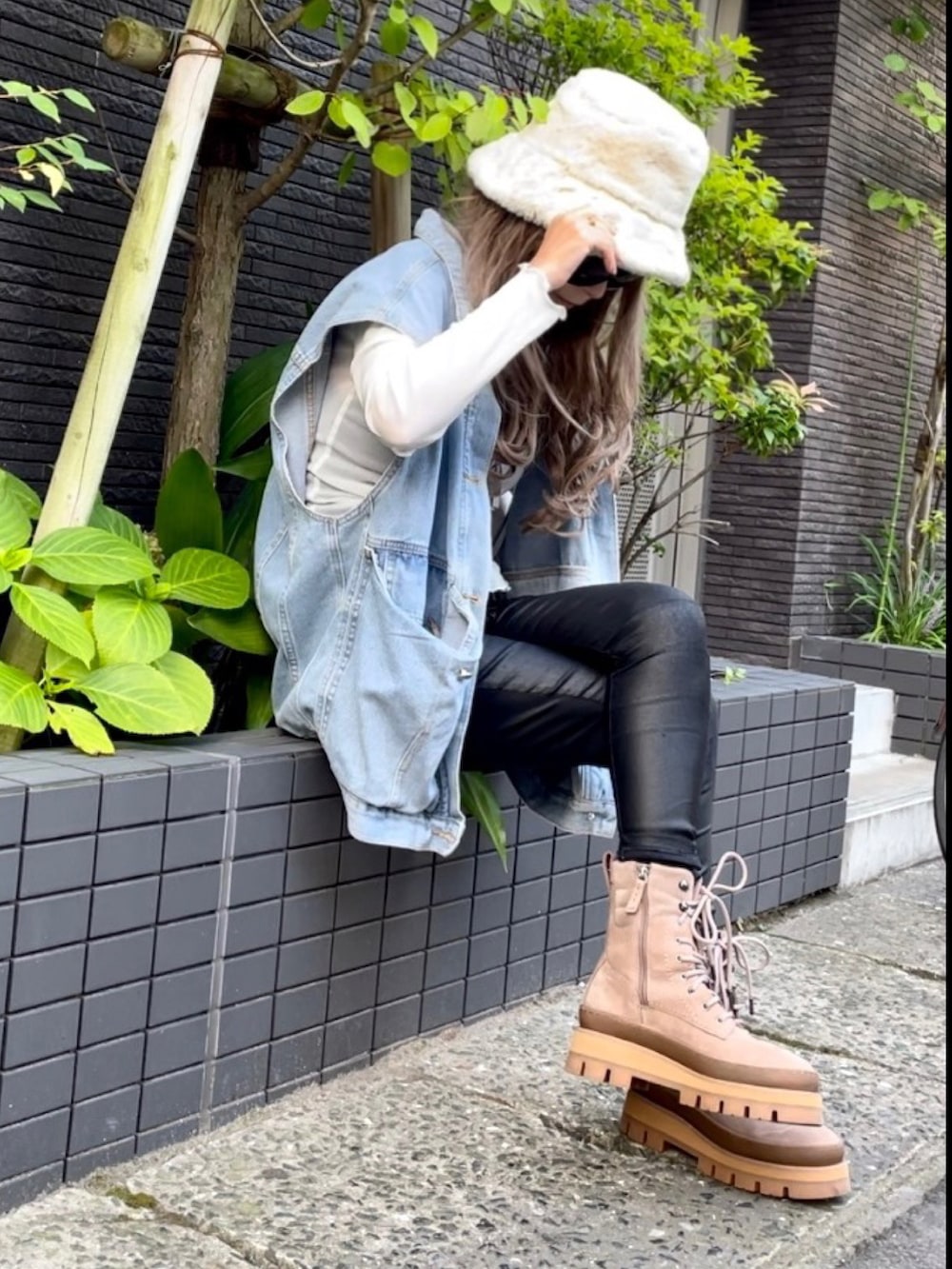 ブルー系のベスト、ブラック系のその他パンツ、ブラウン系のブーツを着用したレディースの秋コーディネートの5枚目の写真