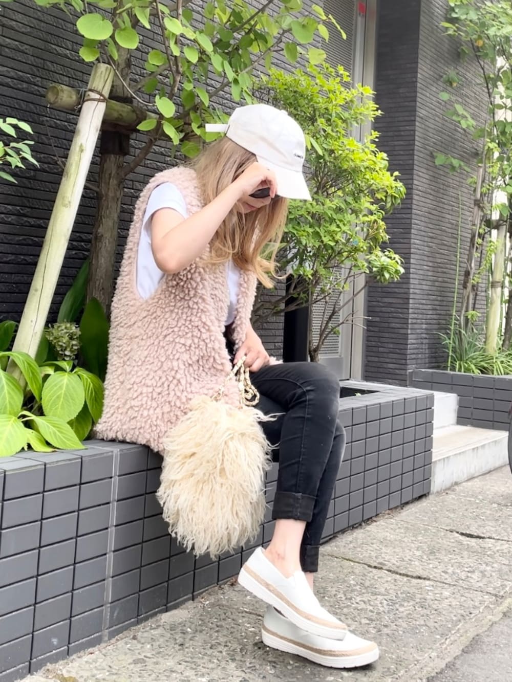 ホワイト系のTシャツ/カットソー、ホワイト系のベスト、ブラック系のデニムパンツを着用したレディースの夏コーディネートの4枚目の写真