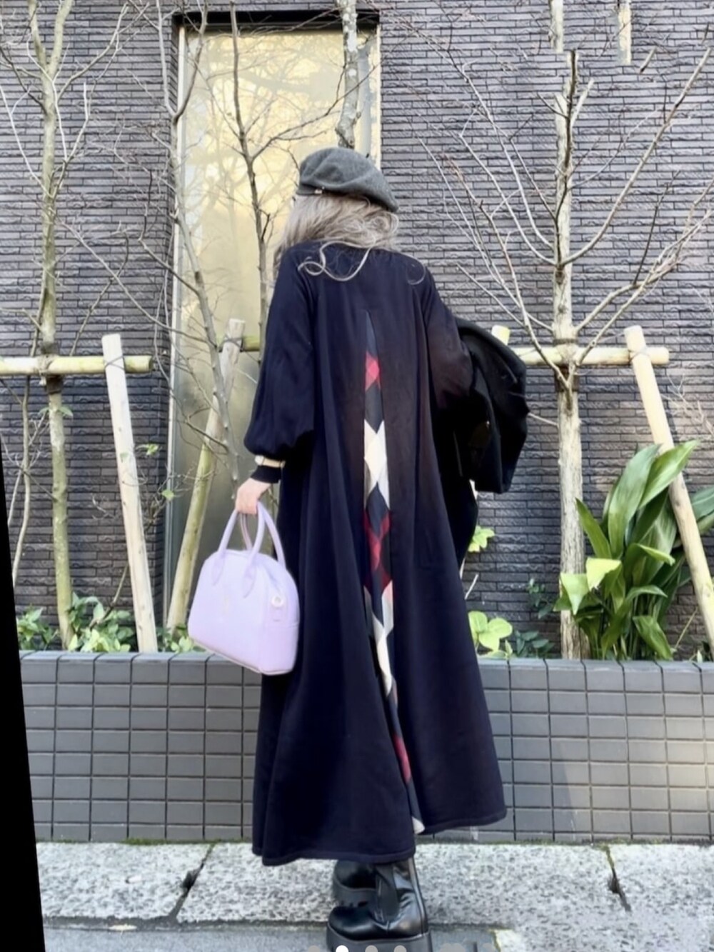 ブルー系のワンピース、パープル系のハンドバッグ、ブラック系のブーツを着用したレディースの冬コーディネートの3枚目の写真