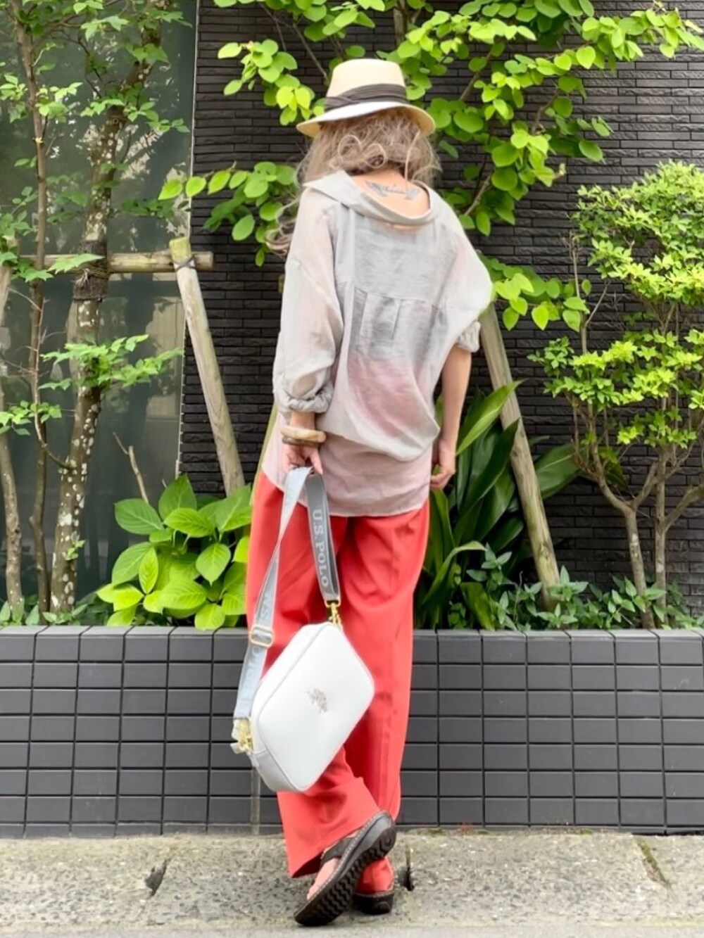 ブラウン系のタンクトップ、グレー系のシャツ/ブラウス、オレンジ系のスラックスを着用したレディースの夏コーディネートの3枚目の写真