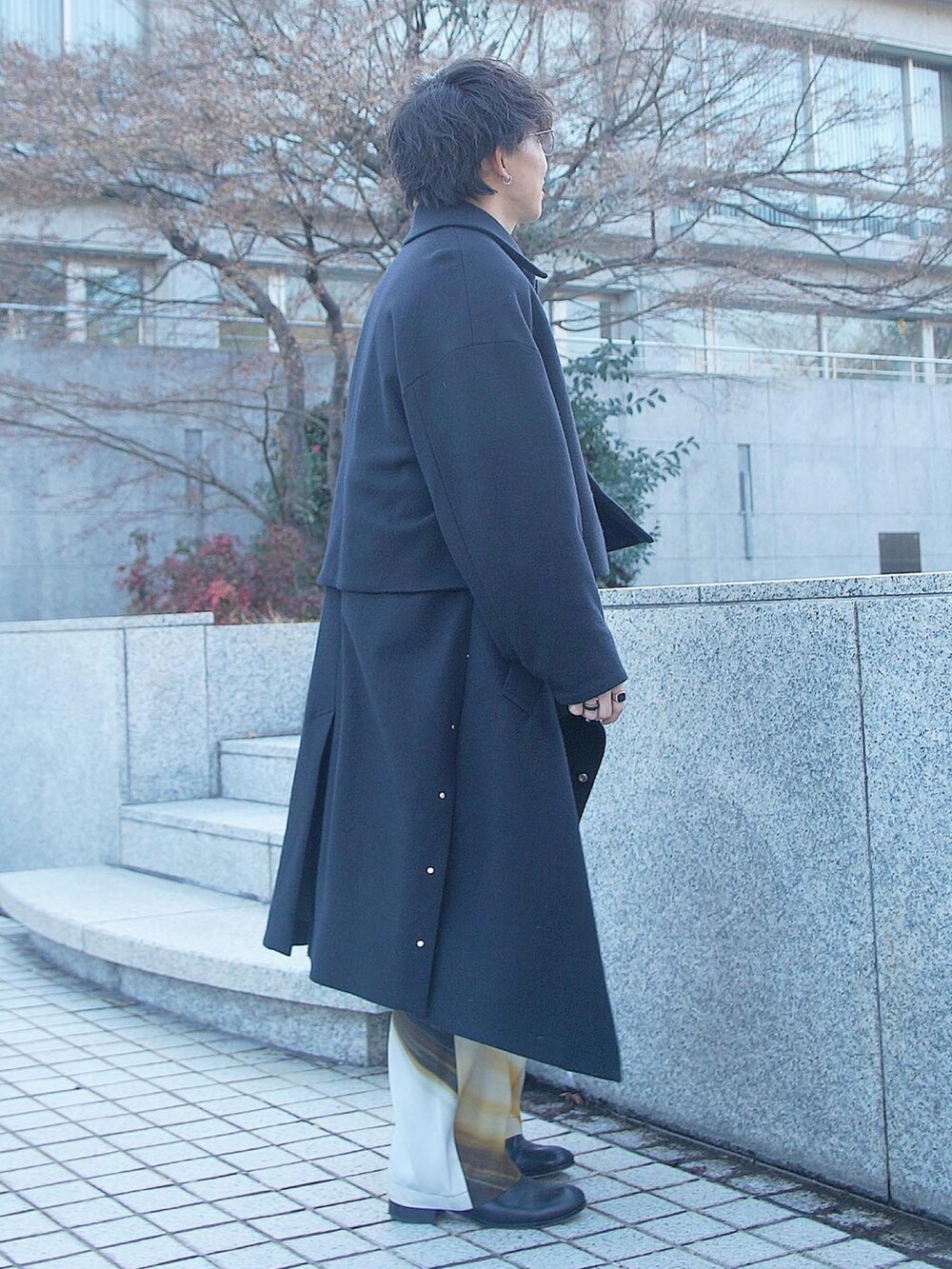 その他のベスト、ブラック系のスウェット、ブラック系のステンカラーコートを着用したメンズの冬コーディネートの3枚目の写真