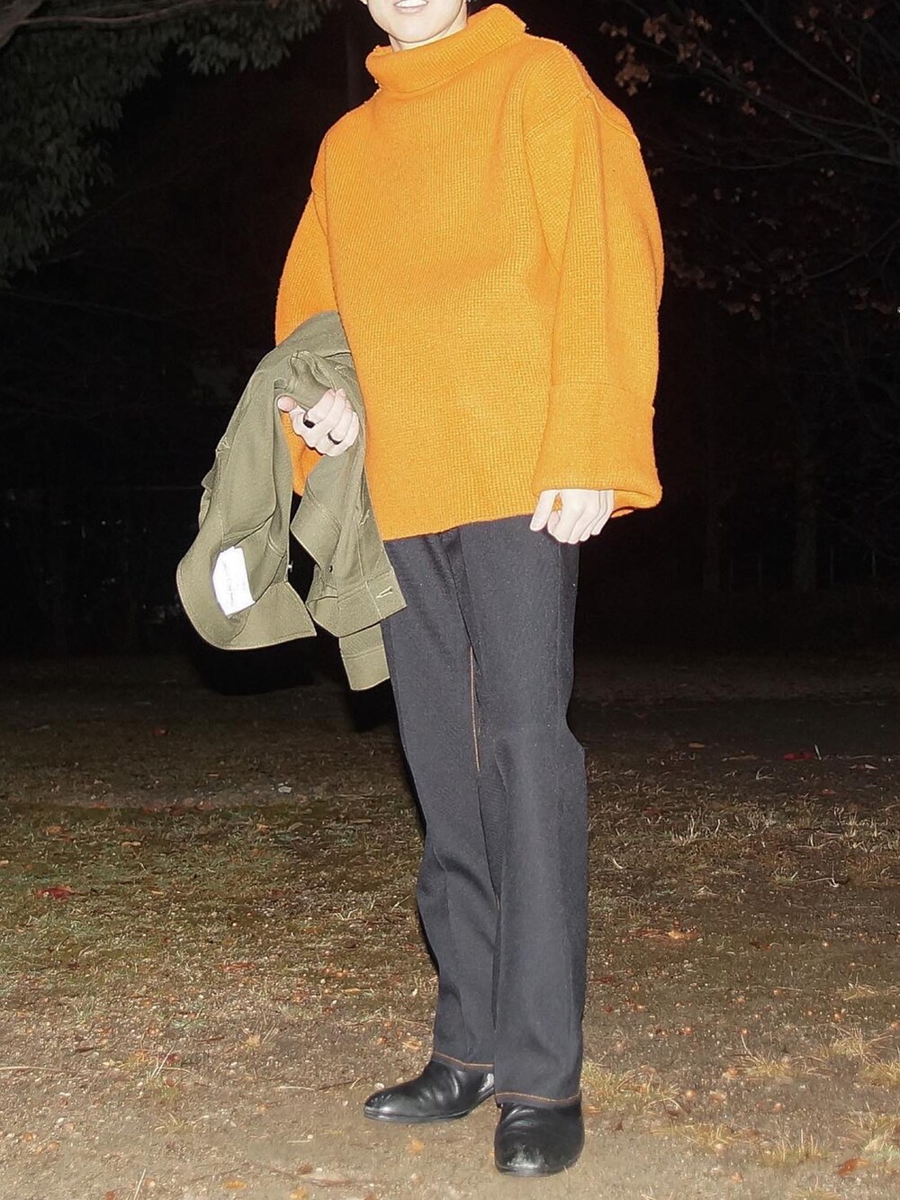 オレンジ系のニット/セーター、ブラック系のその他パンツ、ブラック系のブーツを着用したメンズの冬コーディネートの2枚目の写真