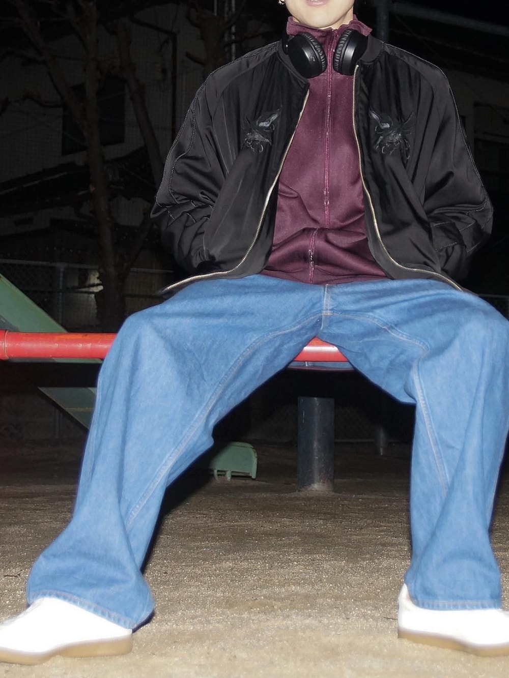 ブラック系のブルゾン、パープル系のジャージ、ブルー系のデニムパンツを着用したメンズの冬コーディネートの2枚目の写真