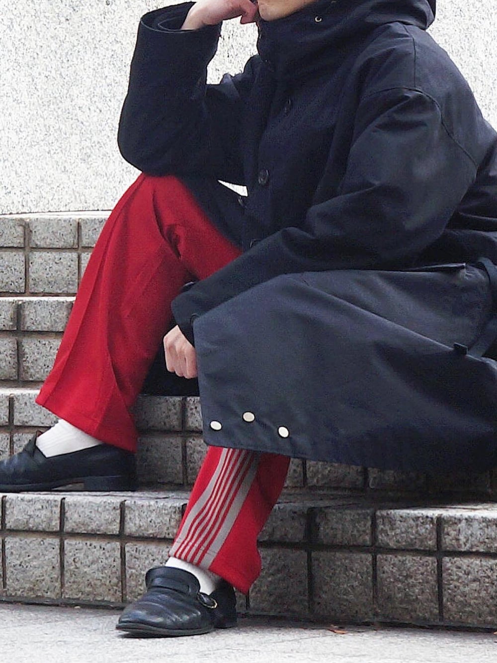 ブラック系のモッズコート、レッド系のその他パンツ、ブラック系のローファーを着用したメンズの冬コーディネートの2枚目の写真