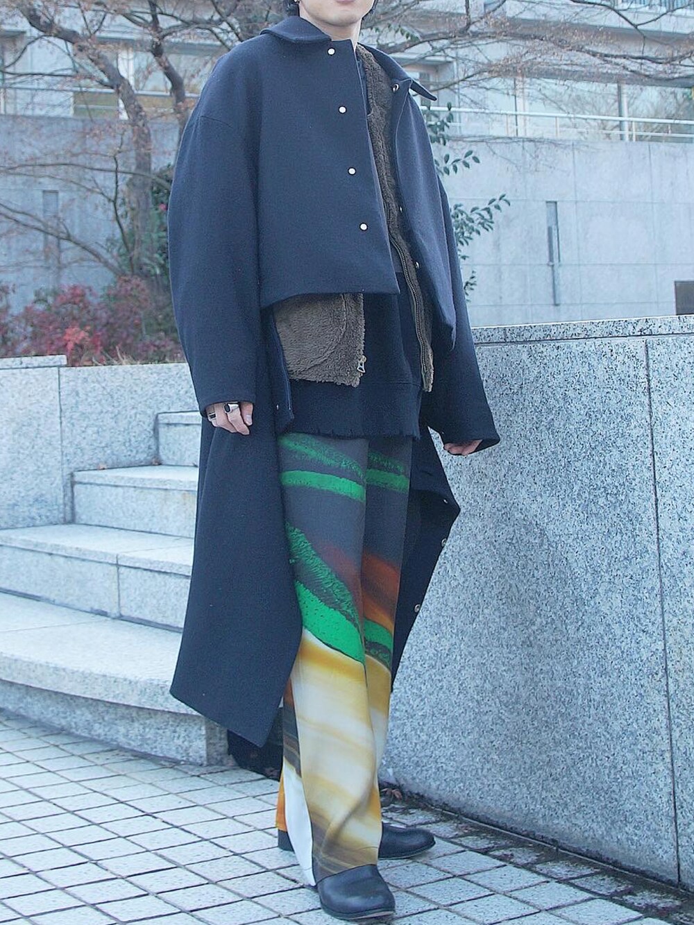 その他のベスト、ブラック系のスウェット、ブラック系のステンカラーコートを着用したメンズの冬コーディネートの2枚目の写真