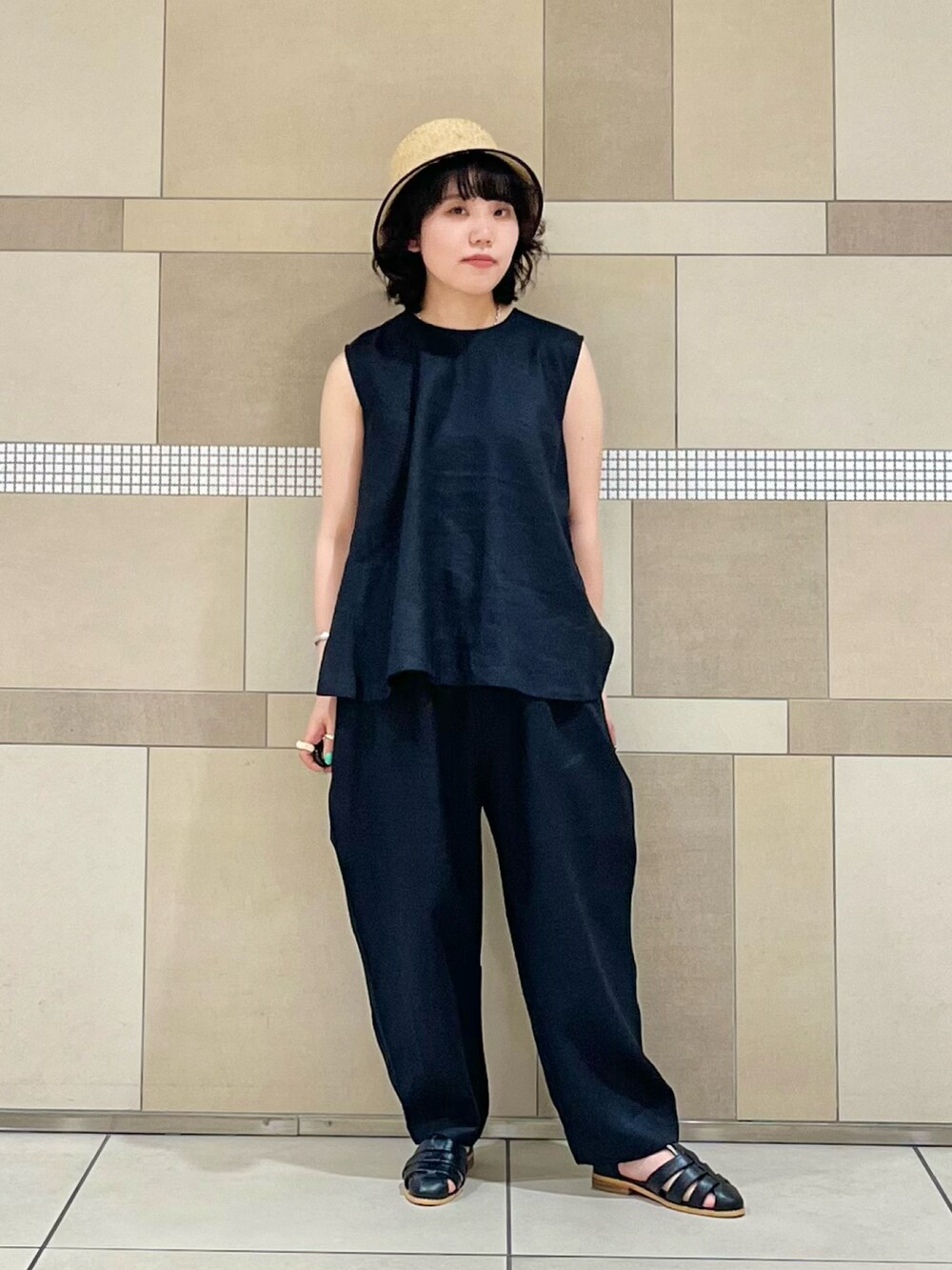 ブラック系のその他パンツ、ブラック系のシャツ/ブラウス、ブラック系のサンダルを着用したレディースの春コーディネートの2枚目の写真