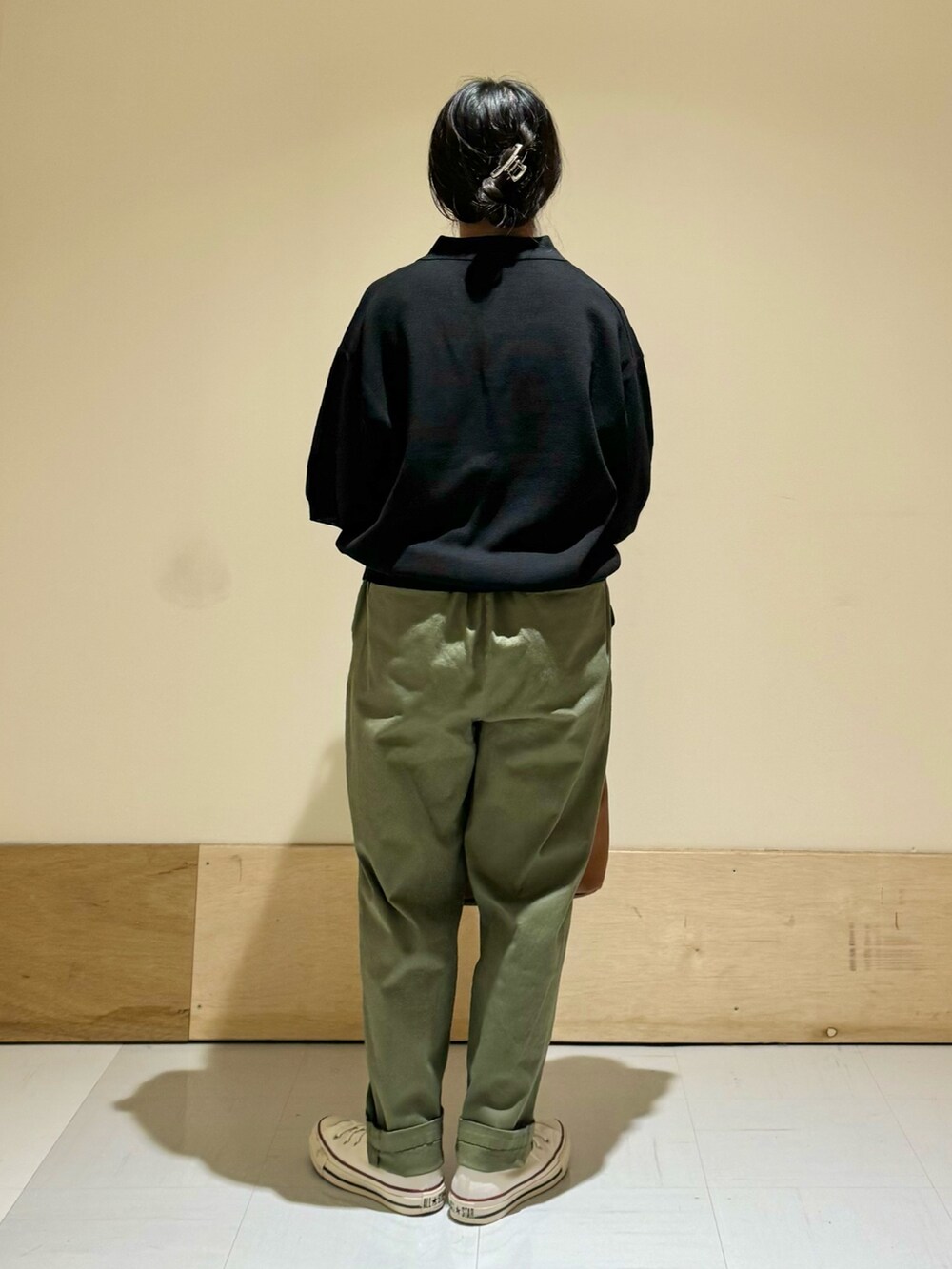 イエロー系のショルダーバッグ、ブラック系のニット/セーター、グリーン系のその他パンツを着用したレディースの夏コーディネートの3枚目の写真