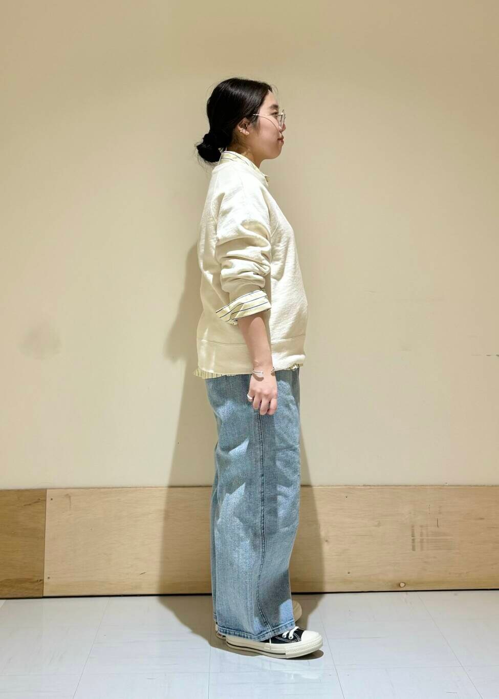 ブルー系のデニムパンツ、ホワイト系のスウェットを着用したレディースの冬コーディネートの2枚目の写真