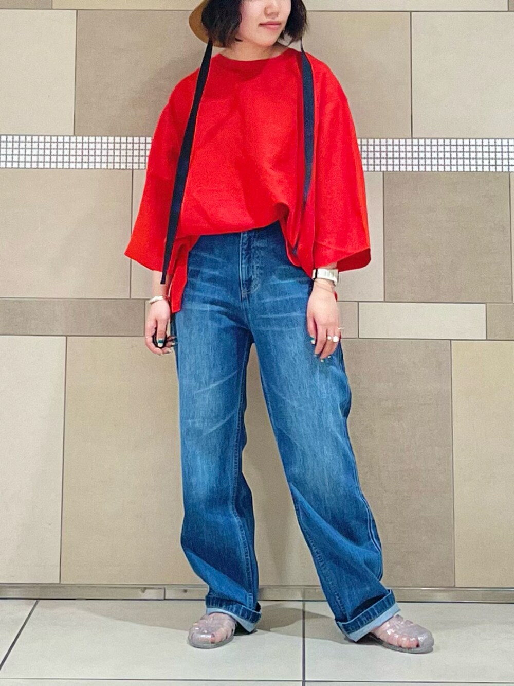 レッド系のTシャツ/カットソー、ブルー系のデニムパンツを着用したレディースの夏コーディネートの2枚目の写真